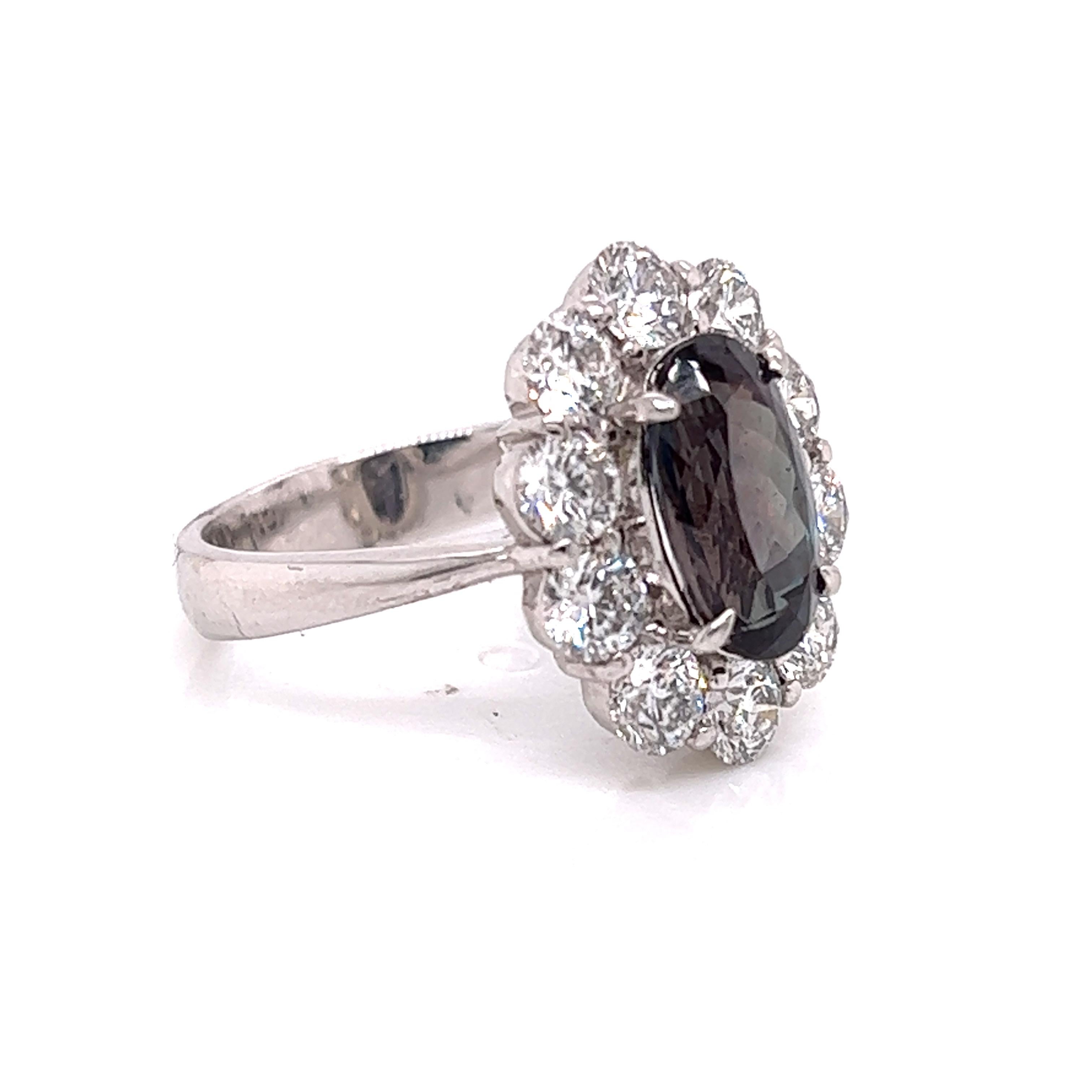 This is a gorgeous natural AAA quality oval Alexandrite surrounded by dainty diamonds that is set in a vintage platinum setting. This ring features a natural 2.82 carat oval alexandrite that is certified by the Gemological Institute of America (GIA)