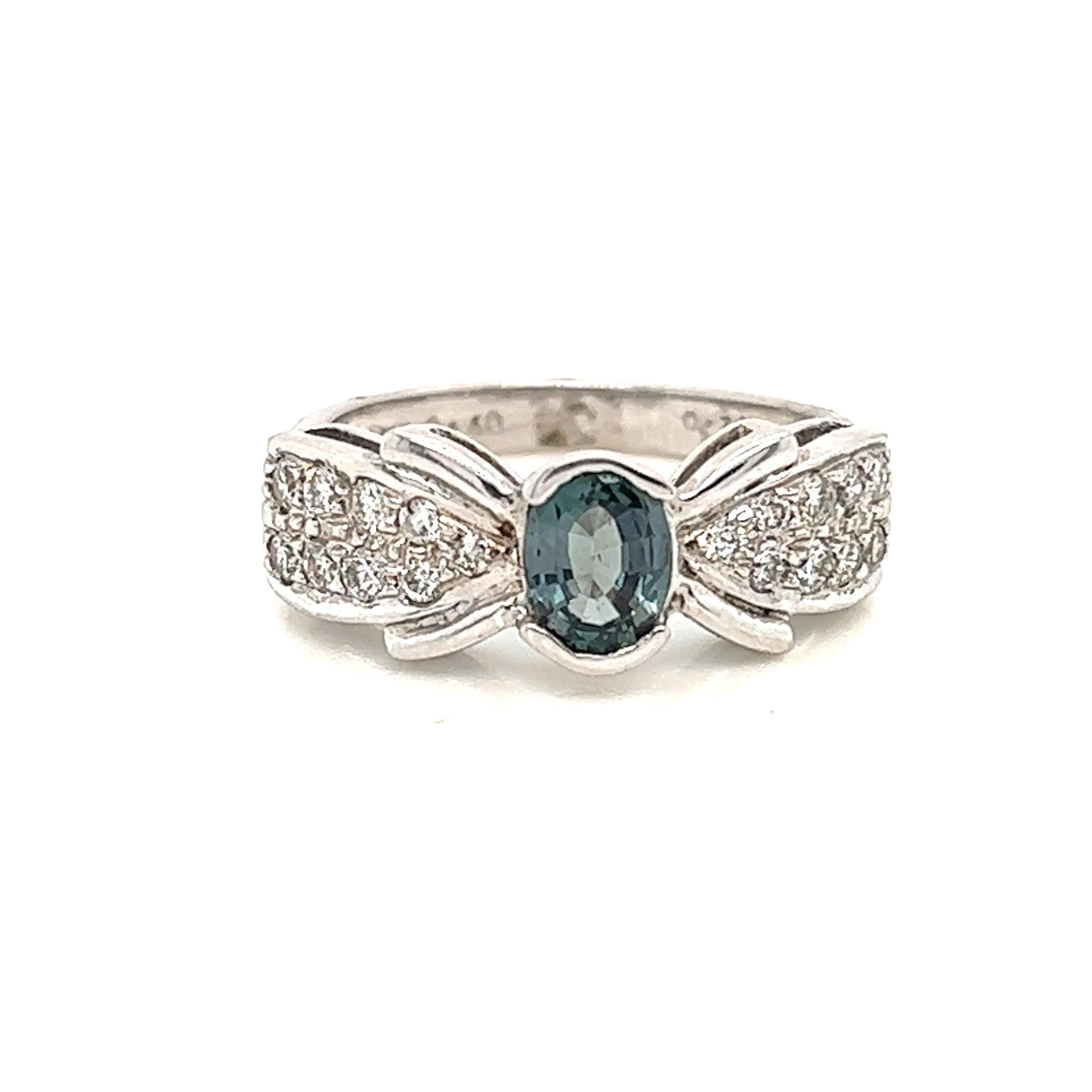 This is a gorgeous natural AAA quality oval Alexandrite surrounded by dainty diamonds that are set in a vintage white gold setting. This ring features a natural 0.68 carat oval alexandrite that is certified by the Gemological Institute of America