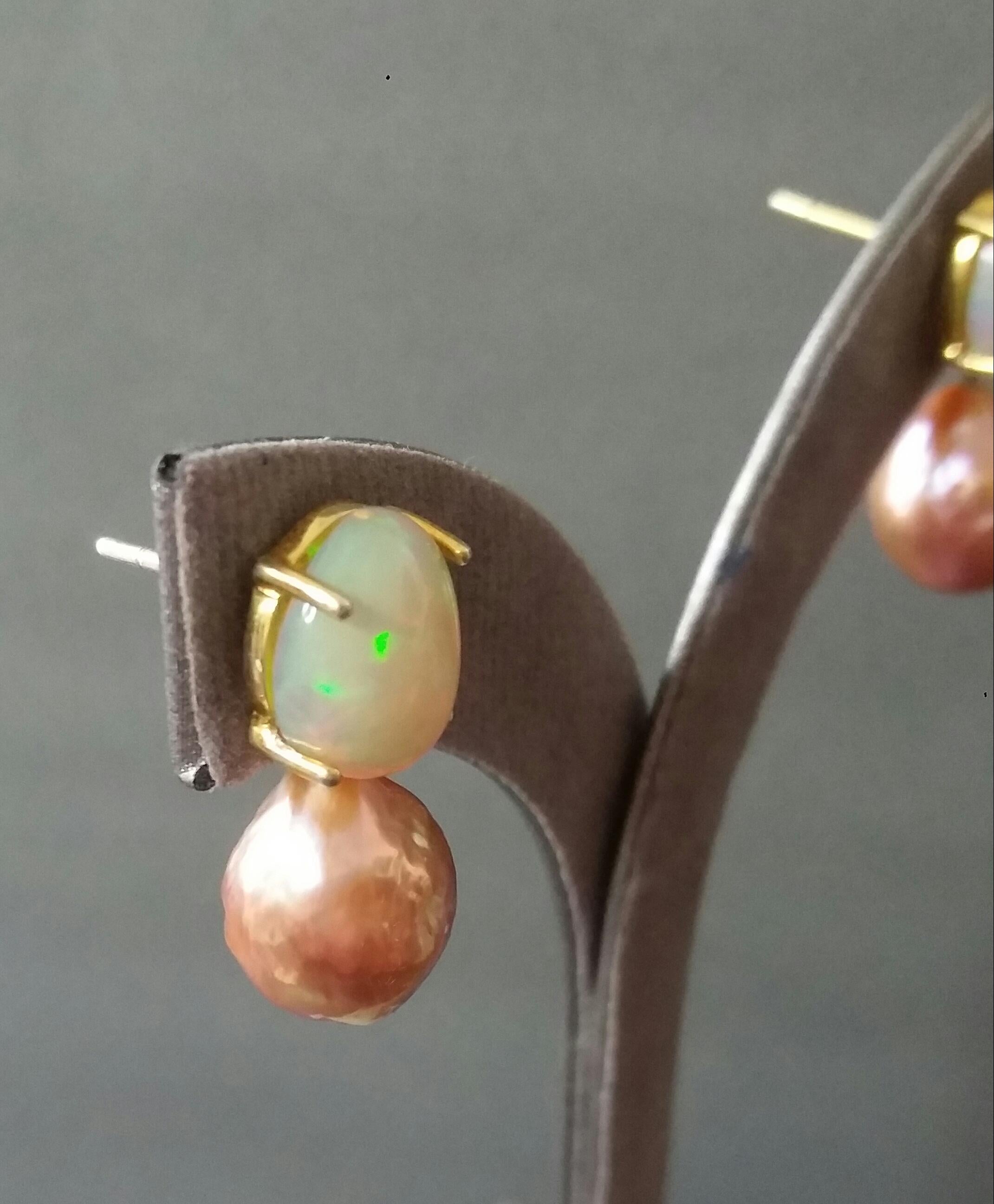 Simple chic stud earrings with a pair of Oval Solid Opal Cabs measuring 9 x 11 mm set in solid 14 Kt. yellow gold on the top and in the lower parts 2 high luster Natural Golden Color  Baroque Pearls measuring 11x13 mm and weighing 20 carats.

In