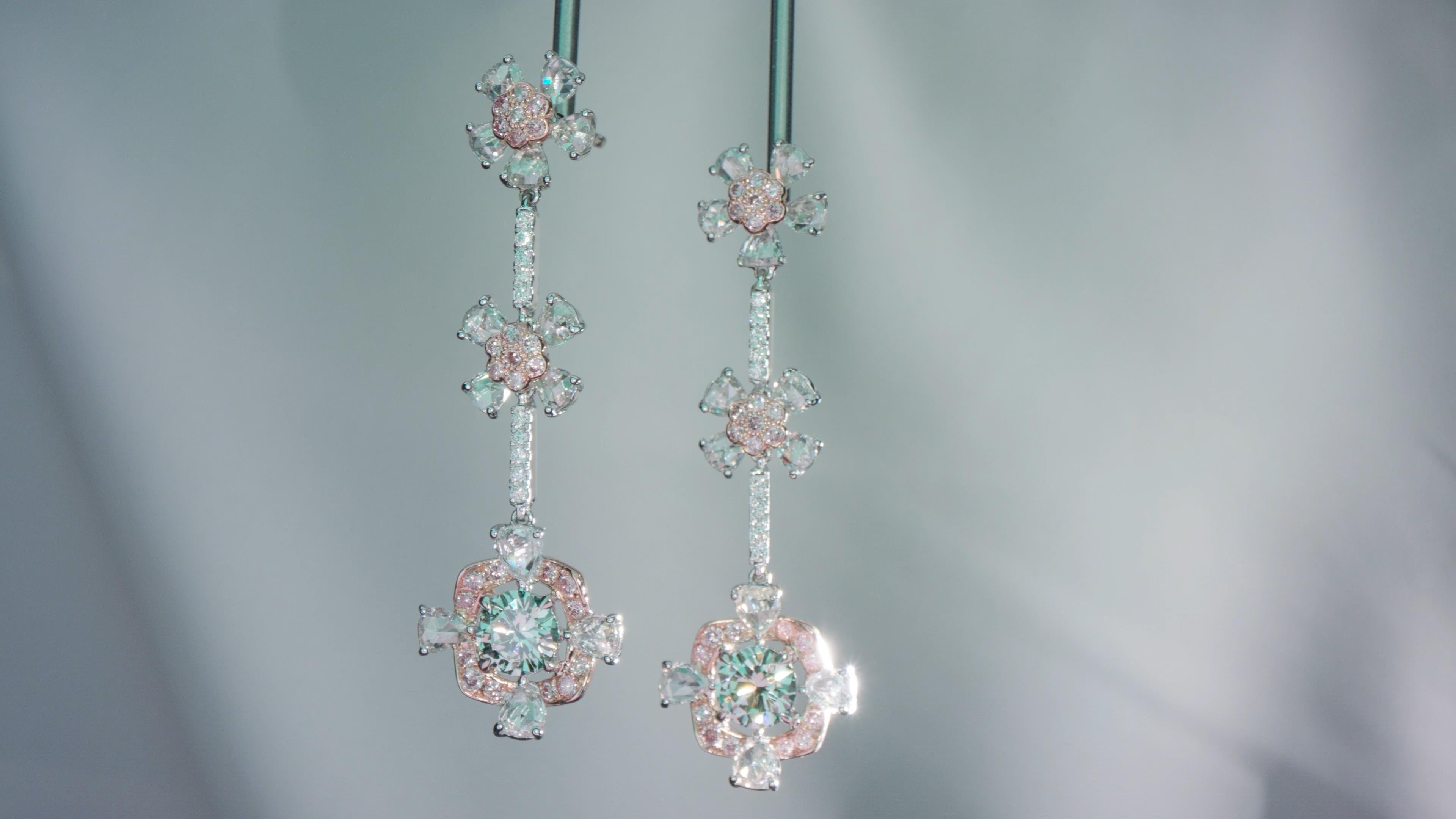 This stunning pair of white and natural color green and pink diamond dangle earrings are crafted in 18k white and rose gold. Featuring two of the rarest types of natural color diamonds, these earrings stand out from the rest! A combination of