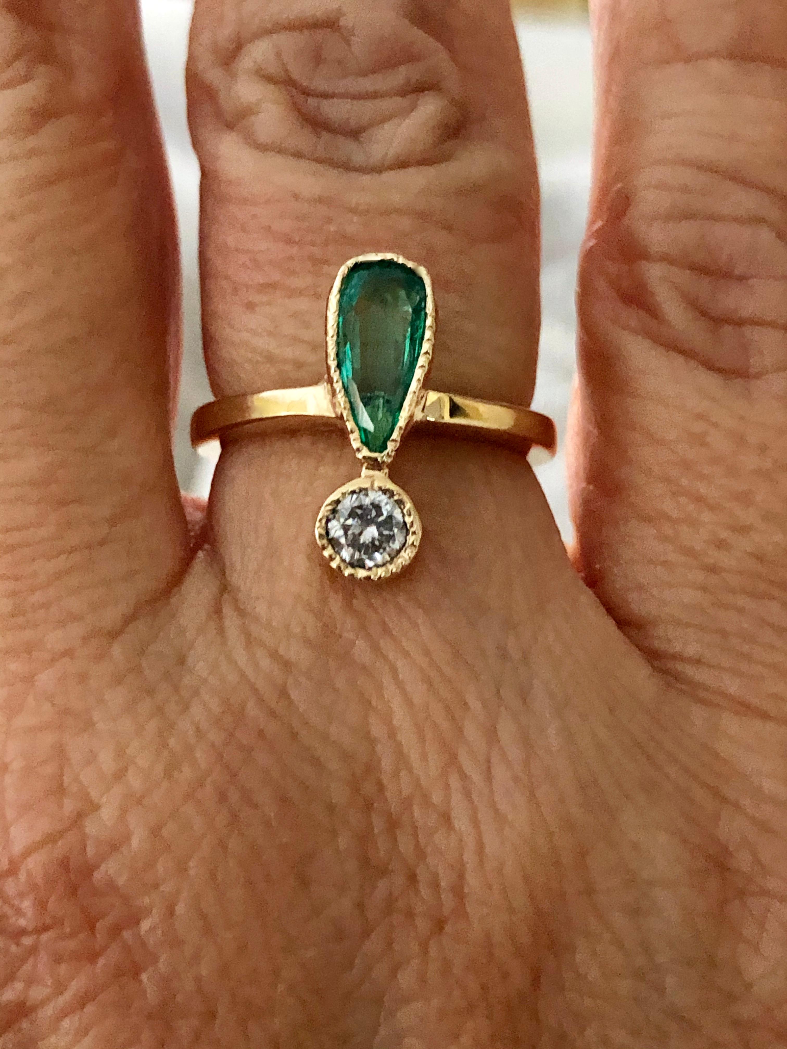 An Antique Style Emerald and Diamond Gold Ring Inspire in the early 1900's The 18K yellow gold ring is bezel-set with a pear-shaped 0.85 carat natural Colombian emerald medium green color, excellent clarity, and a round cut diamond, approximately