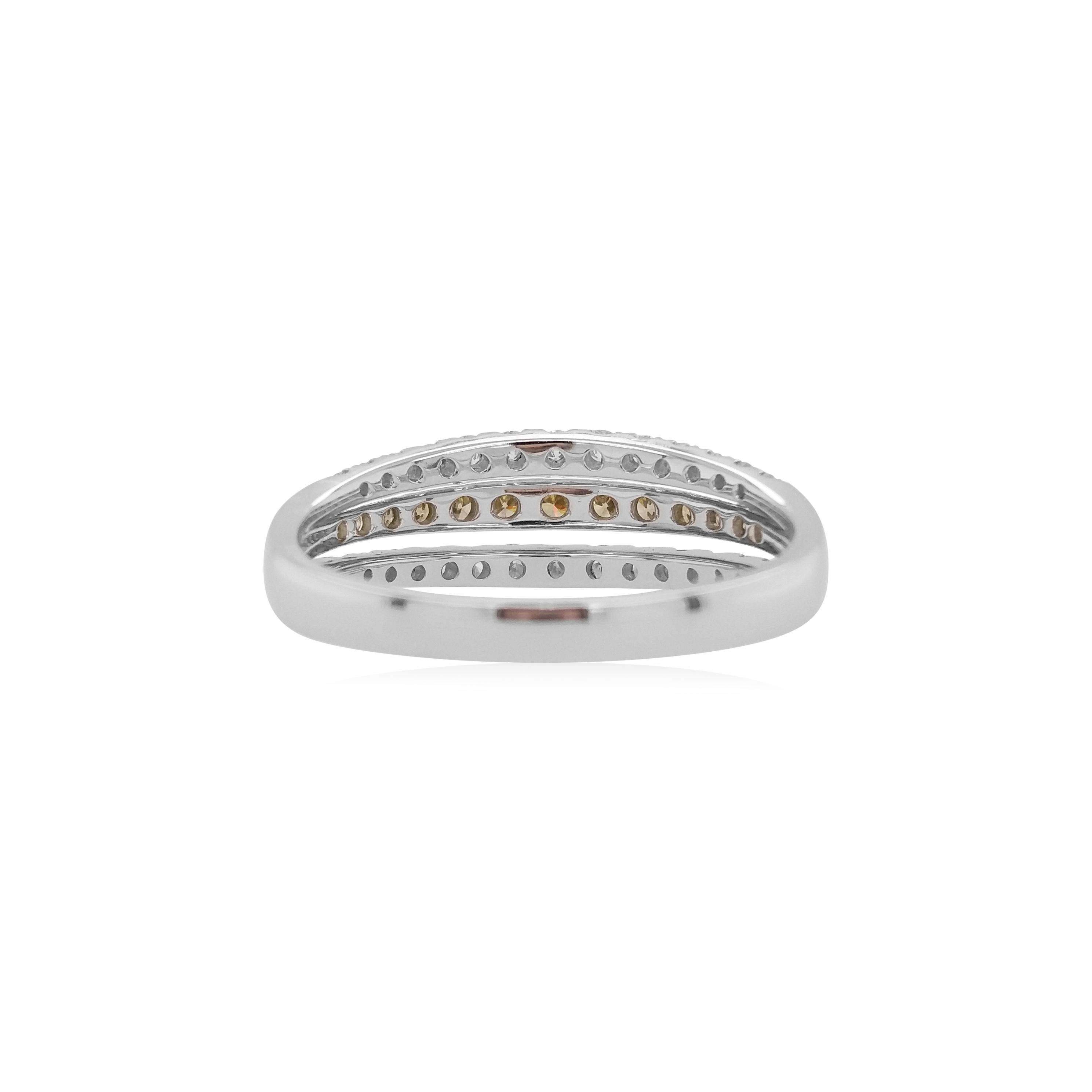 This graceful ring band features a row of glistening Green Diamonds at the center of its design. Perfectly highlighted by the 18 Karat white gold setting and dazzling white diamonds alongside. A must-have ring to any jewellery box, this piece would