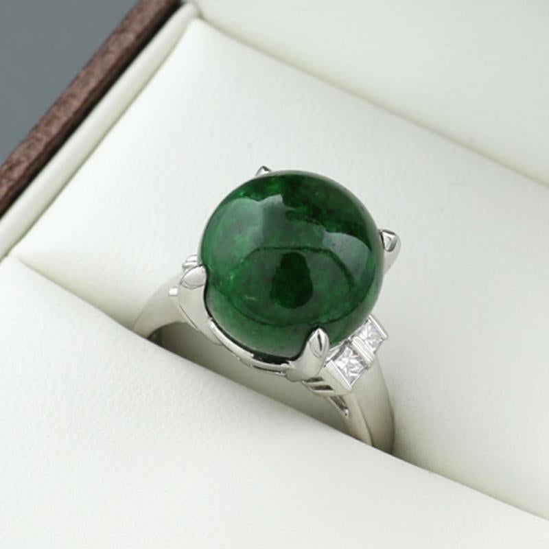 A unique ring, featuring a stunning centerpiece—a round, polished ball of vibrant green jade, with a diameter of approximately 12.5 mm, exuding elegance and natural beauty. The shoulders of the ring are beautifully adorned with four sparkling