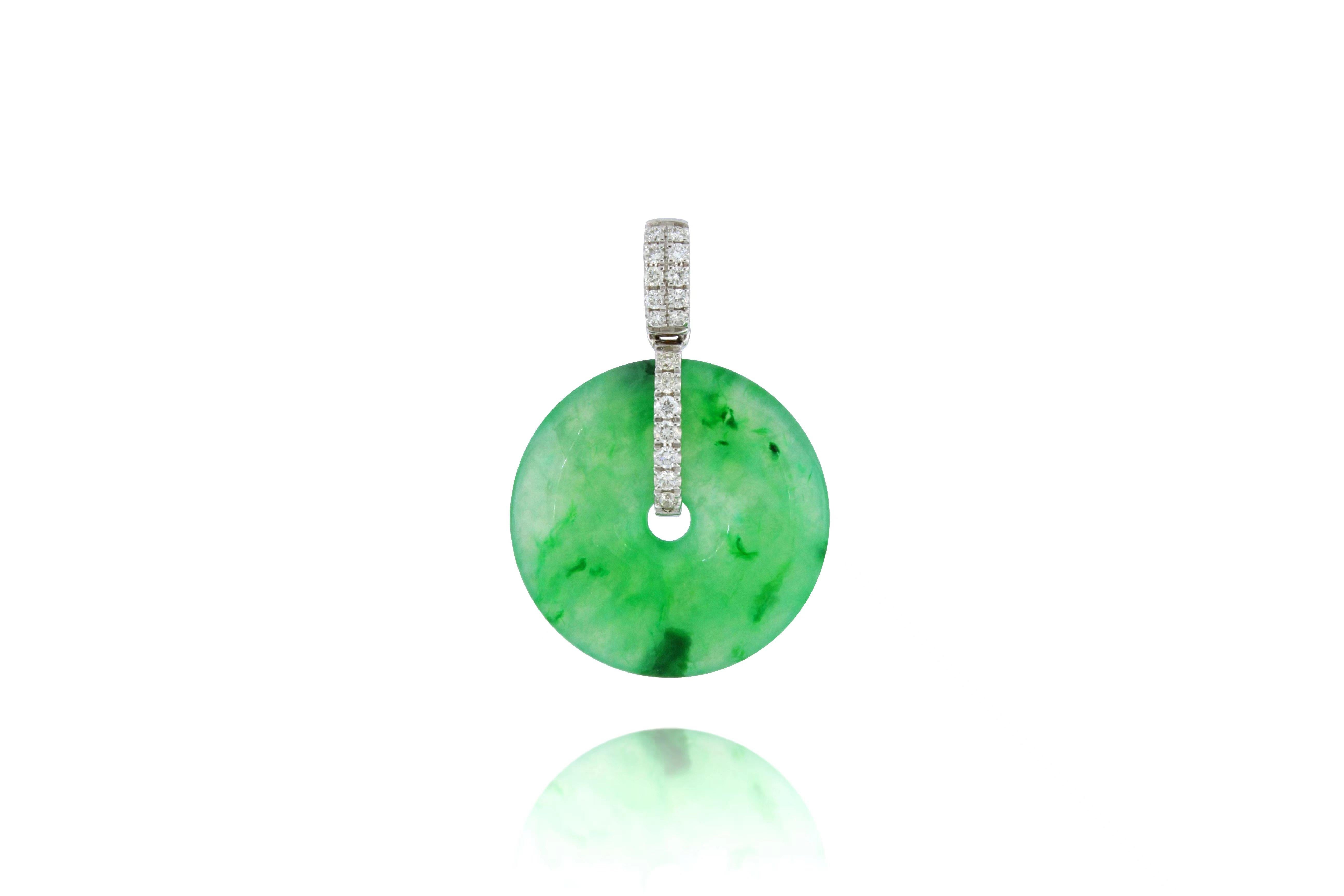 A translucent  green natural jadeite pendant in perfect round shape, decorated with round brilliant-cut diamonds, weighing 0.137 carats in total, mounted in 18 karat white gold. 
The company was founded one and a half centuries ago in Macau. The