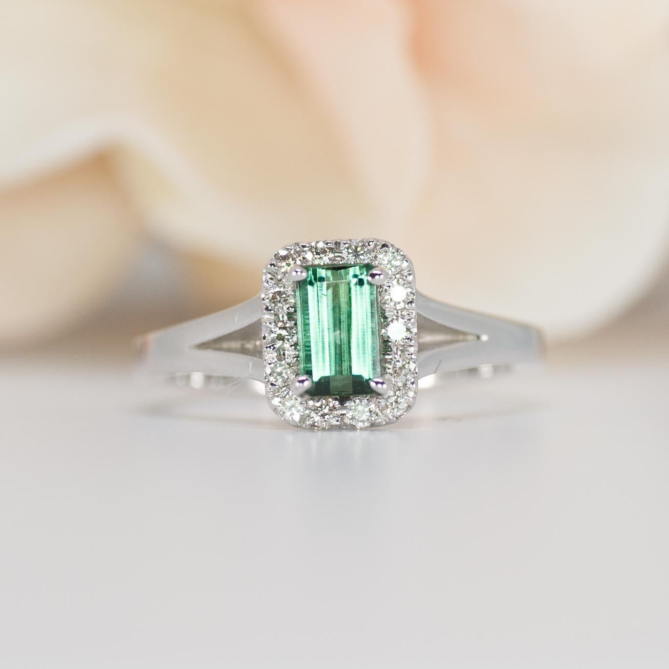 This emerald cut engagement ring features a vibrant, inclusion free green tourmaline with a sparkling halo of diamonds.

This tourmaline engagement ring is perfect for couples on a budget. The green color of the tourmaline is very much like the