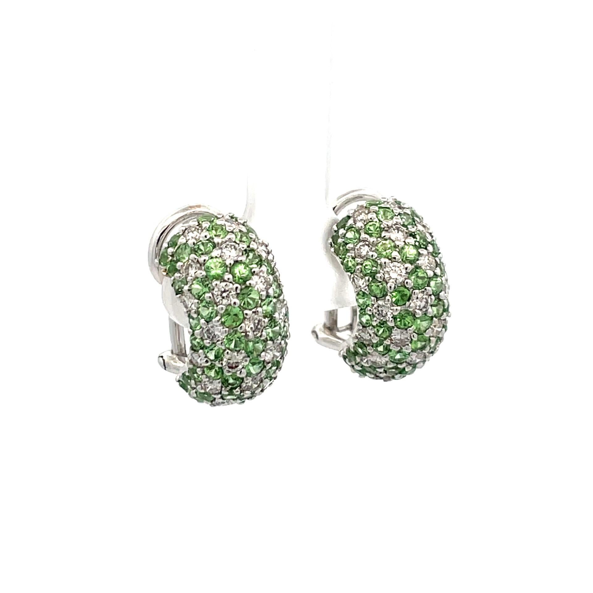 A pair of pave wide huggies set with natural green tsavorite and brilliant cut diamonds in 18kt white gold with a straight post and omega clip system. 

102 natural green tsavorites 4.00ct total weight

44 brilliant cut diamonds 1.29ct total weight,