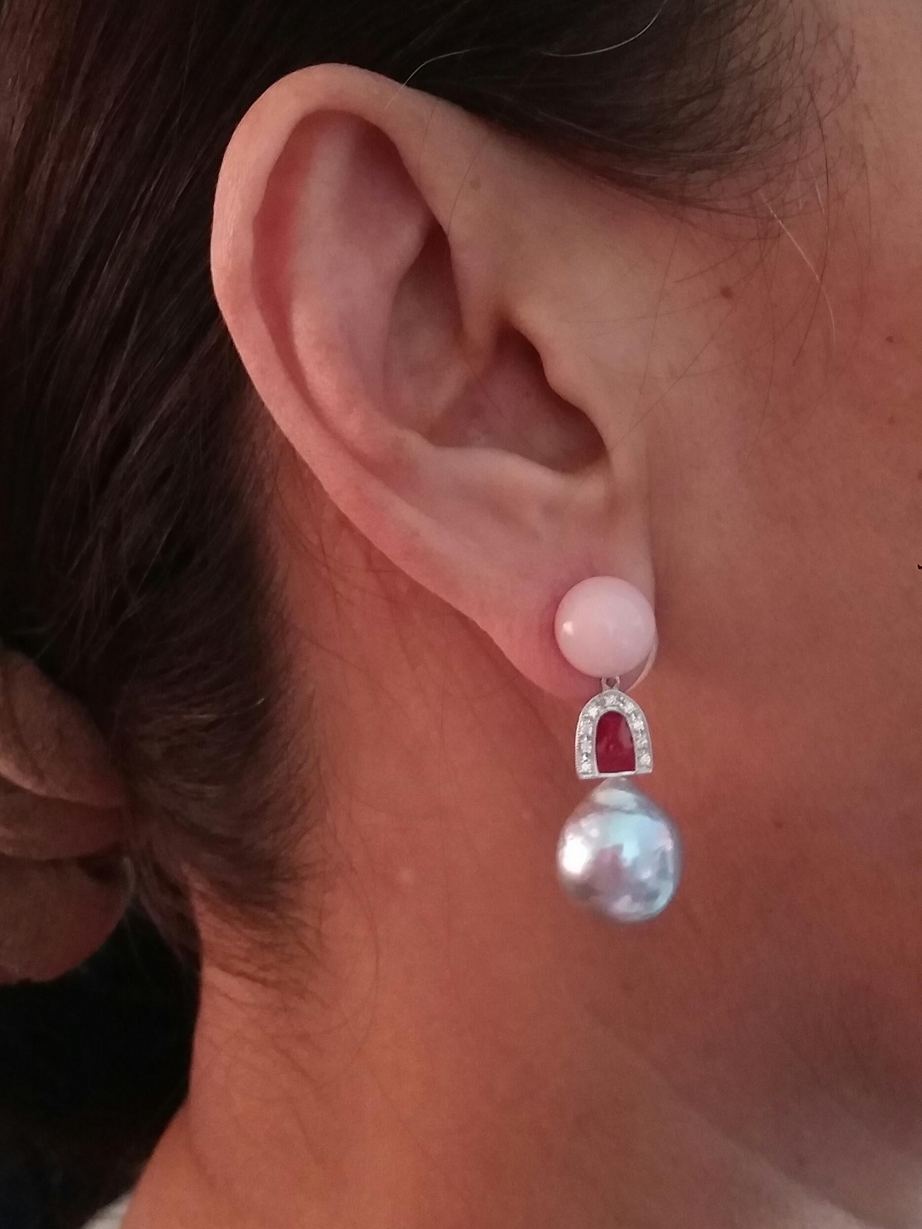 The upper part consists of 2 round cabochons of natural pink opal, then in the central part we have a white gold element, diamonds and red enamel, at the bottom there are 2 baroque pearls of natural grey color with a diameter of 13 mm.
In 1978 our