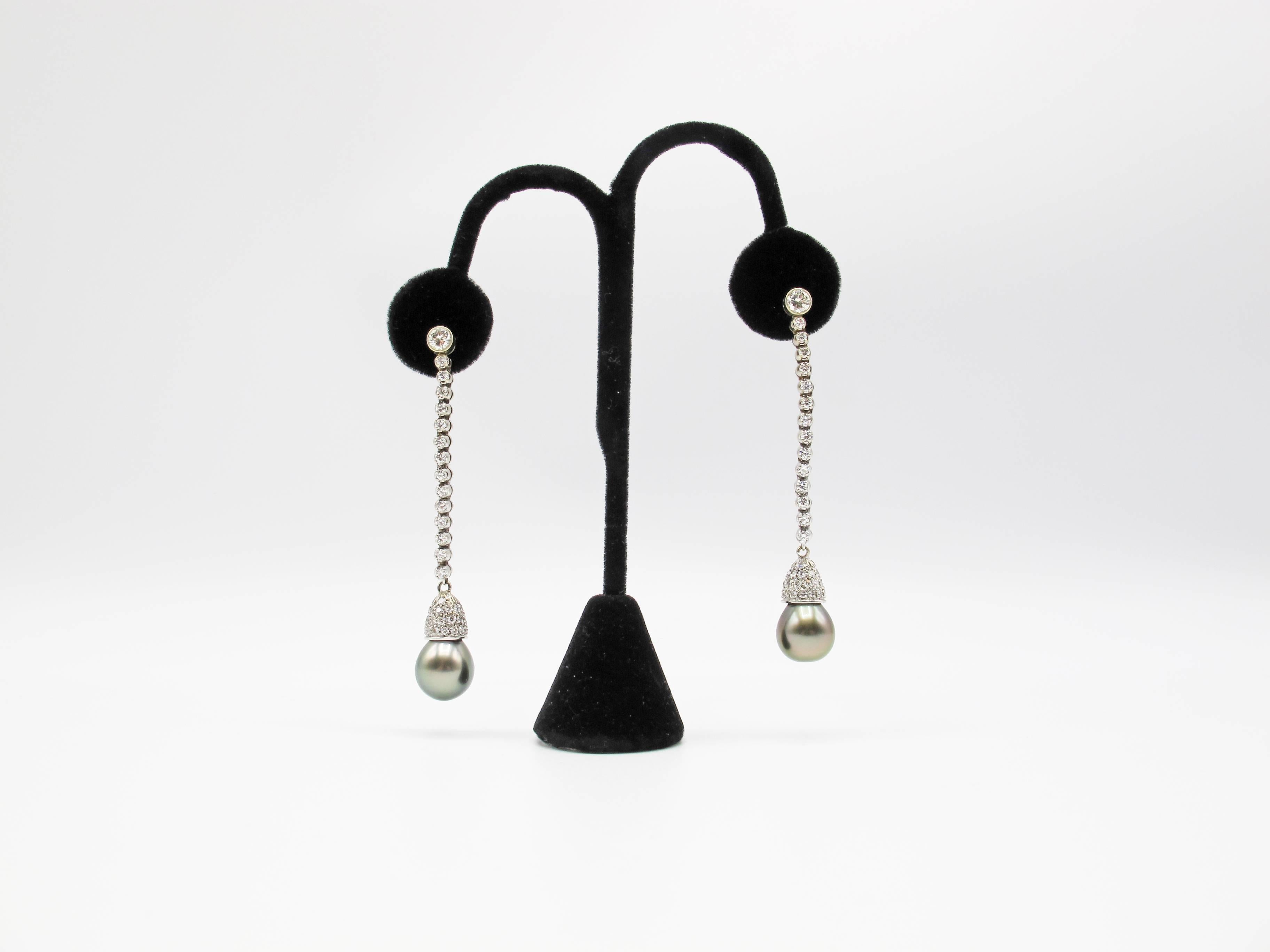 A pair of perfectly matched 12.2 mm Tahitian dark silvery grey South Sea pearls , set in a diamond encrusted cup, extend from a 2” long strand of brilliant cut diamonds,The thick nacre of the pearls give them an incredible luster, with the surface