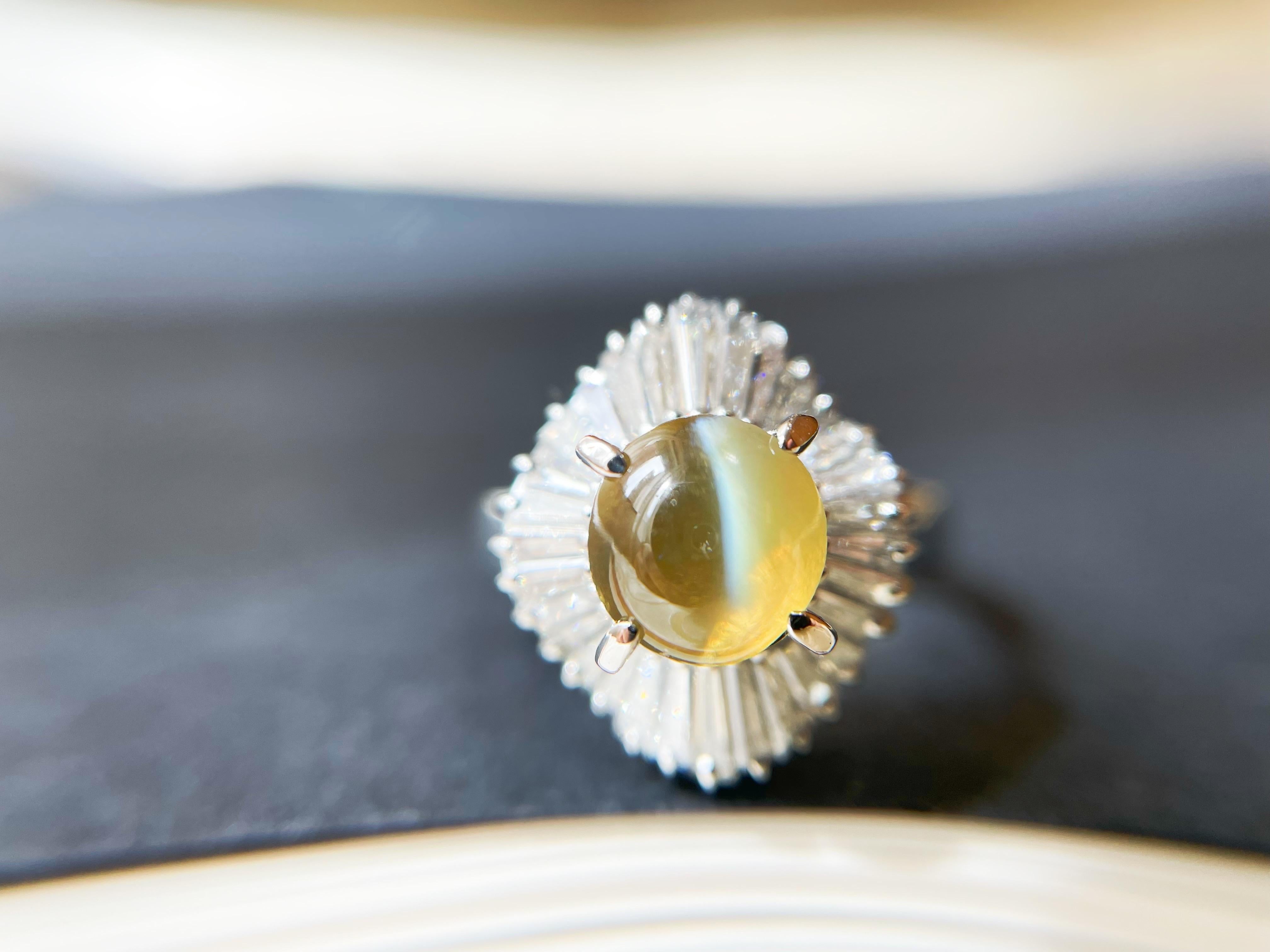 This gorgeous ring features a stunning natural chrysoberyl cat's eye stone displaying a silky band of light running across the center. It is hand-crafted and designed by us and embellished with brilliant diamonds. 

This beautiful ring will make a