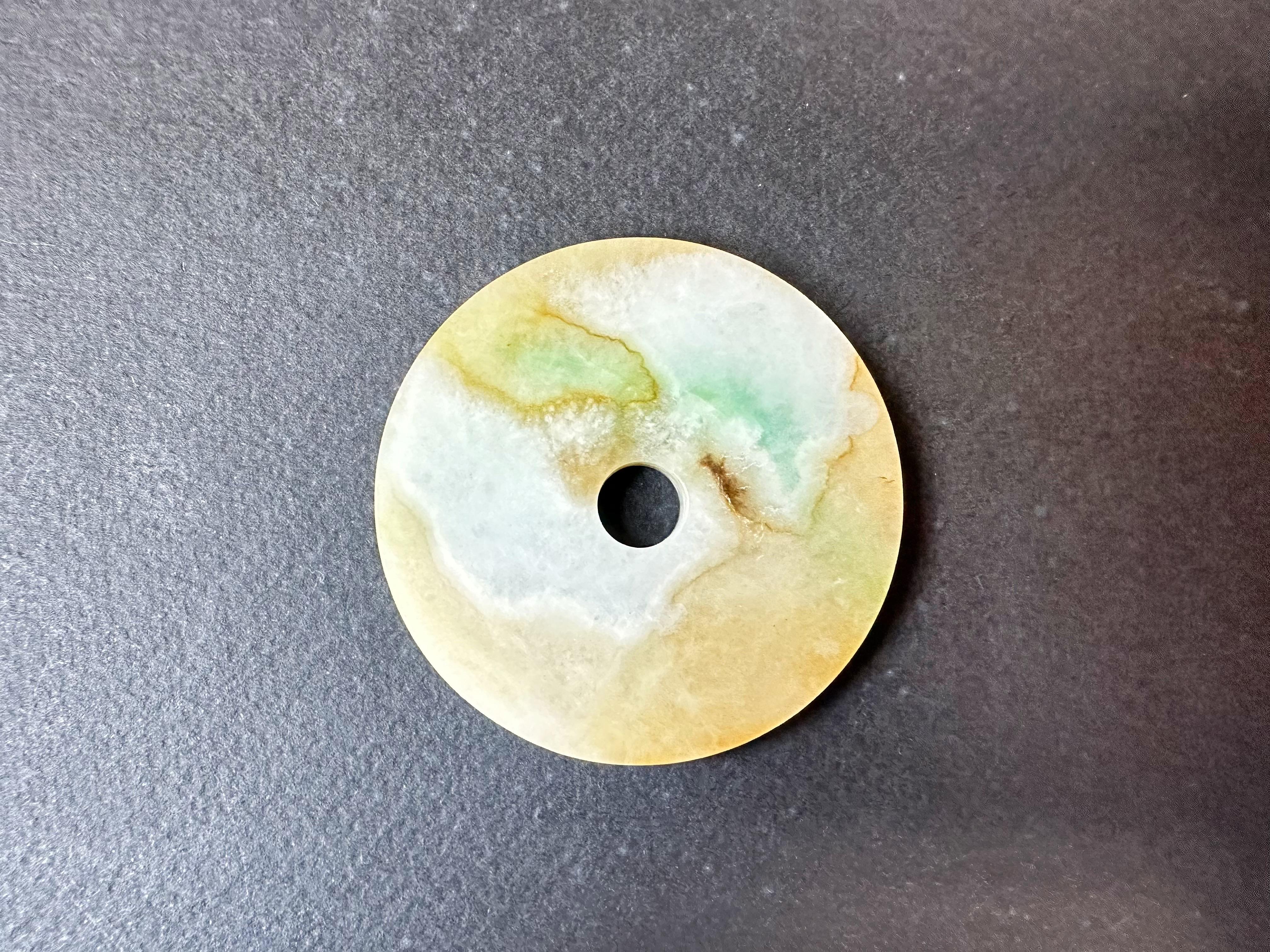 Immergiti nell'affascinante bellezza di questo splendido ciondolo a ciambella in giada naturale tricolore. Realizzato con la migliore giada Myanmar di tipo A, questo ciondolo è un vero capolavoro dell'arte della natura.

La ciambella di giada è