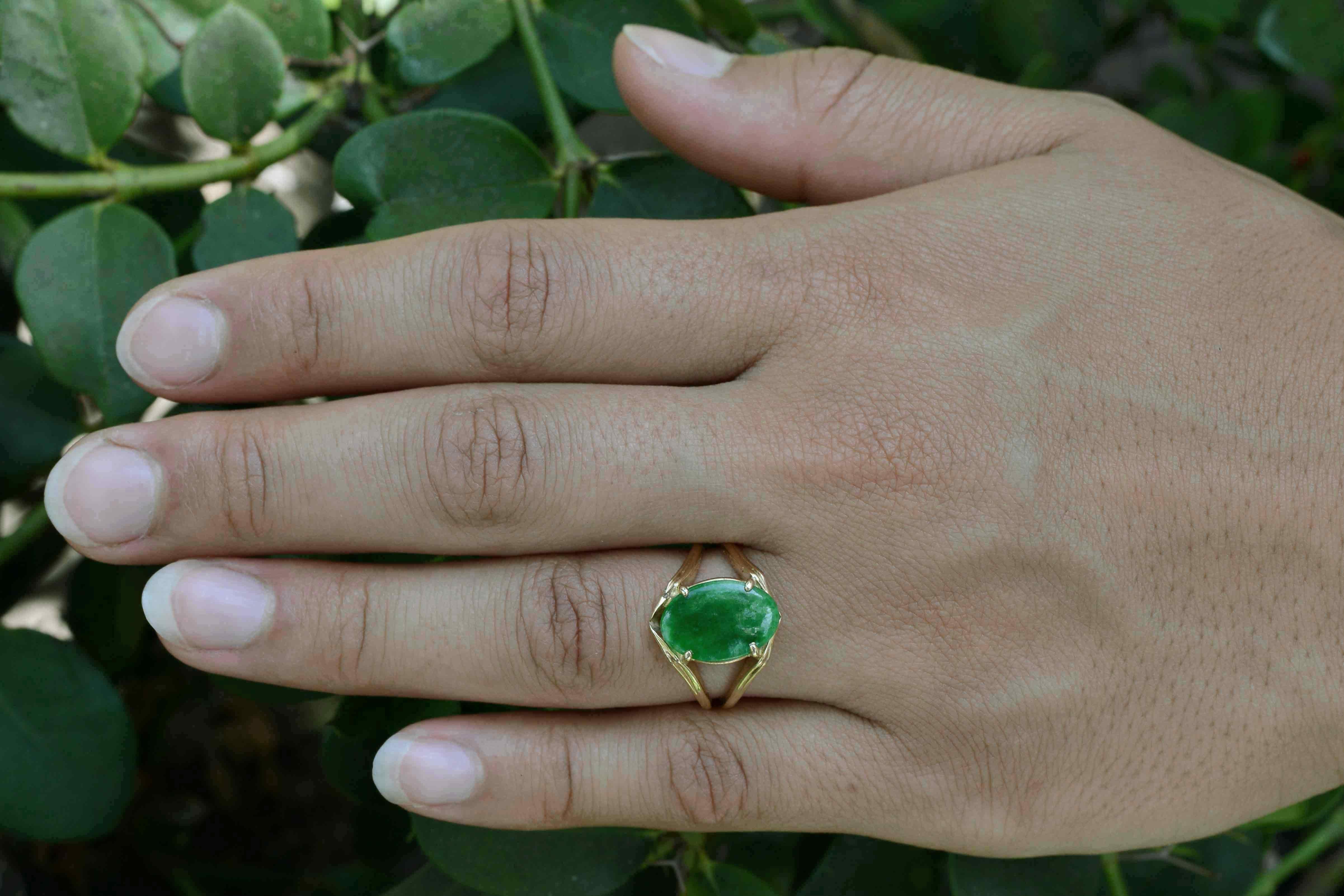 Boasting an outstanding vivid green, this Imperial Jade solitaire ring sits comfortably on your hand in a classic, Mid Century modern setting. The natural oval jadeite gemstone glows from a fire from within. Recently acquired from a local Montecito,