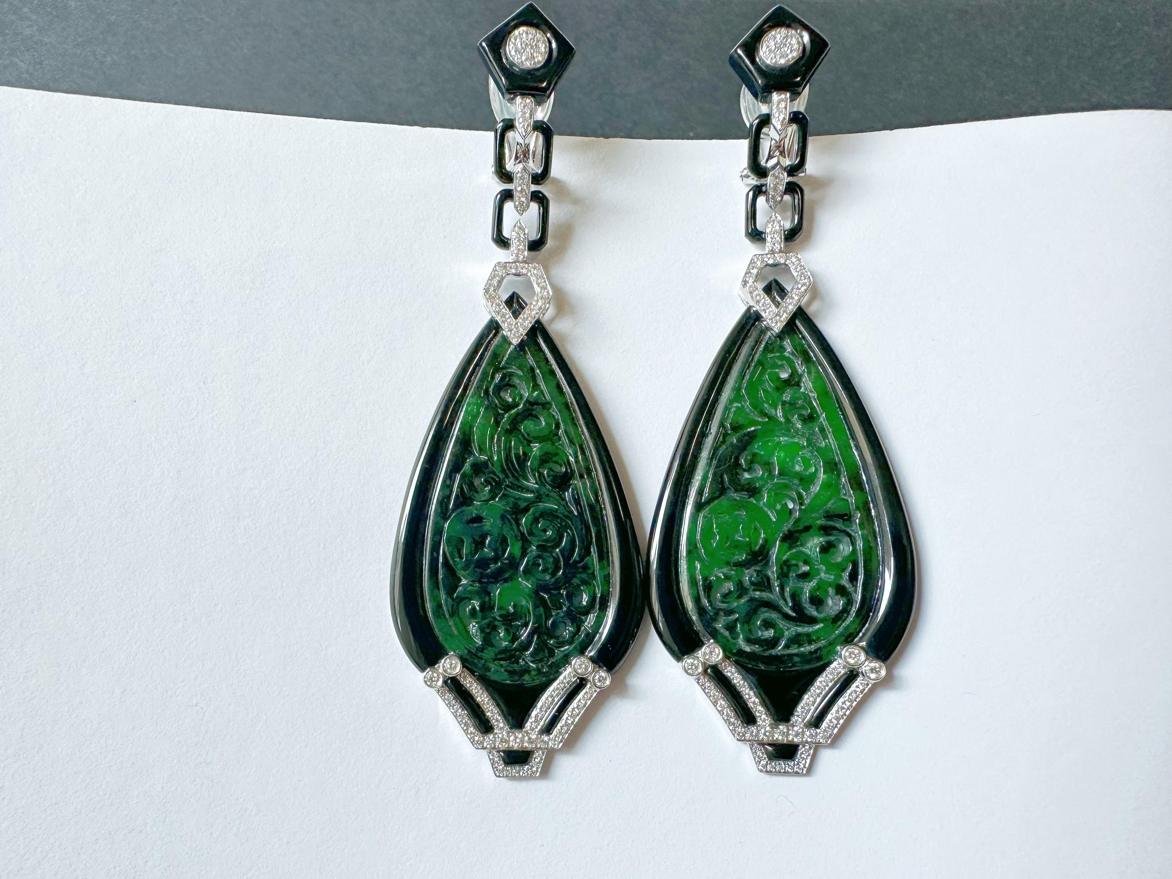 Experience the ultimate luxury with these custom-designed and handcrafted earrings, featuring intense green Myanmar jadeite in a stunning ancient carved drop shape pattern. Framed in 18k white gold and embellished with vibrant black agate and