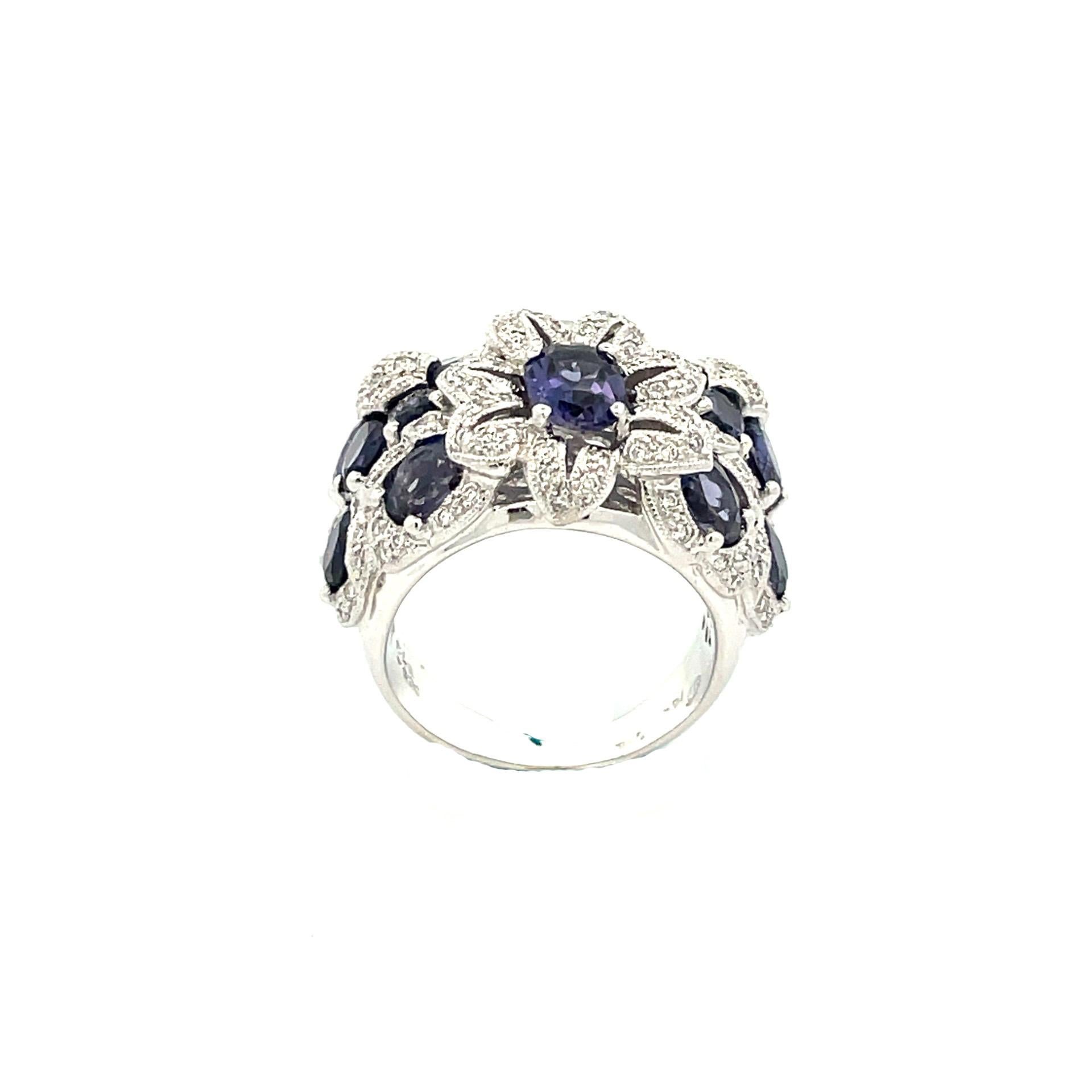 A flower bouquet cluster ring crafted in 18 karat white gold with natural iolite and natural round brilliant cut diamonds. 

18 natural iolite 5.92ct total weight

95 brilliant cut natural diamonds .60ct total weight

18kt white gold weighing 14.40