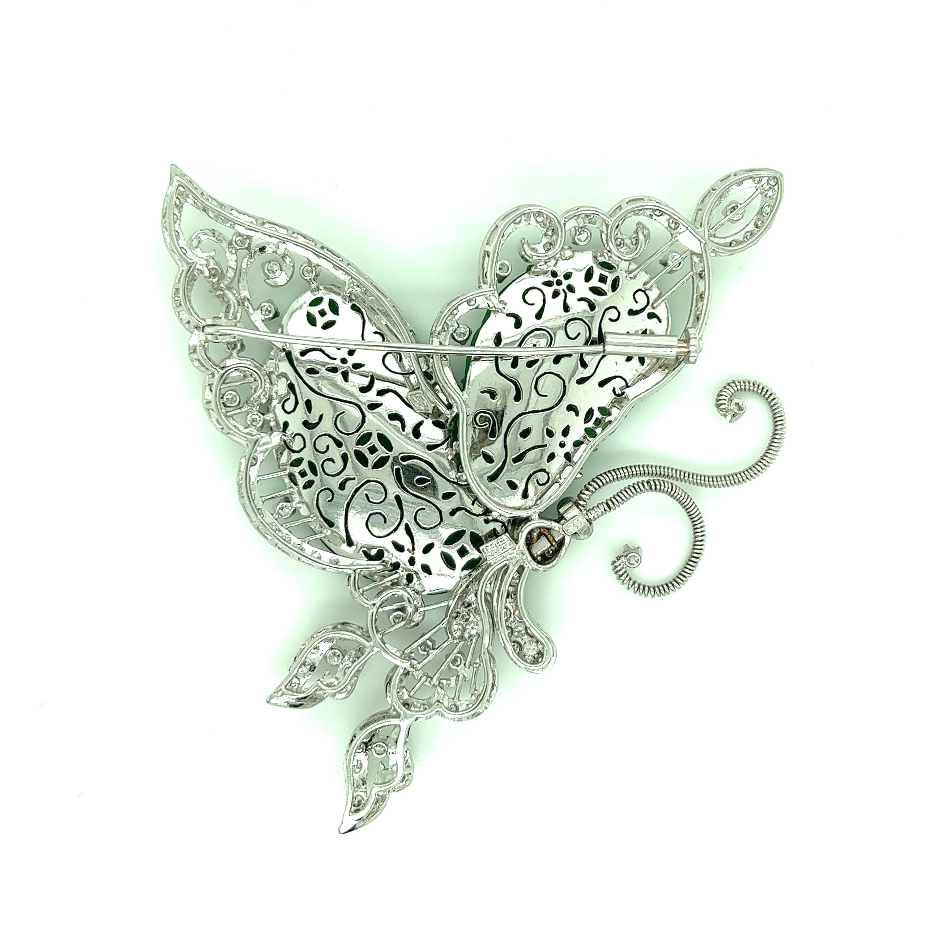A beautiful butterfly made out of type A natural jade and diamonds set on an ornate 18 karat white gold design. The jade has swirl carvings and the diamonds weigh approximately 2.2 carats. This butterfly's antennae is made out of thin spring, which