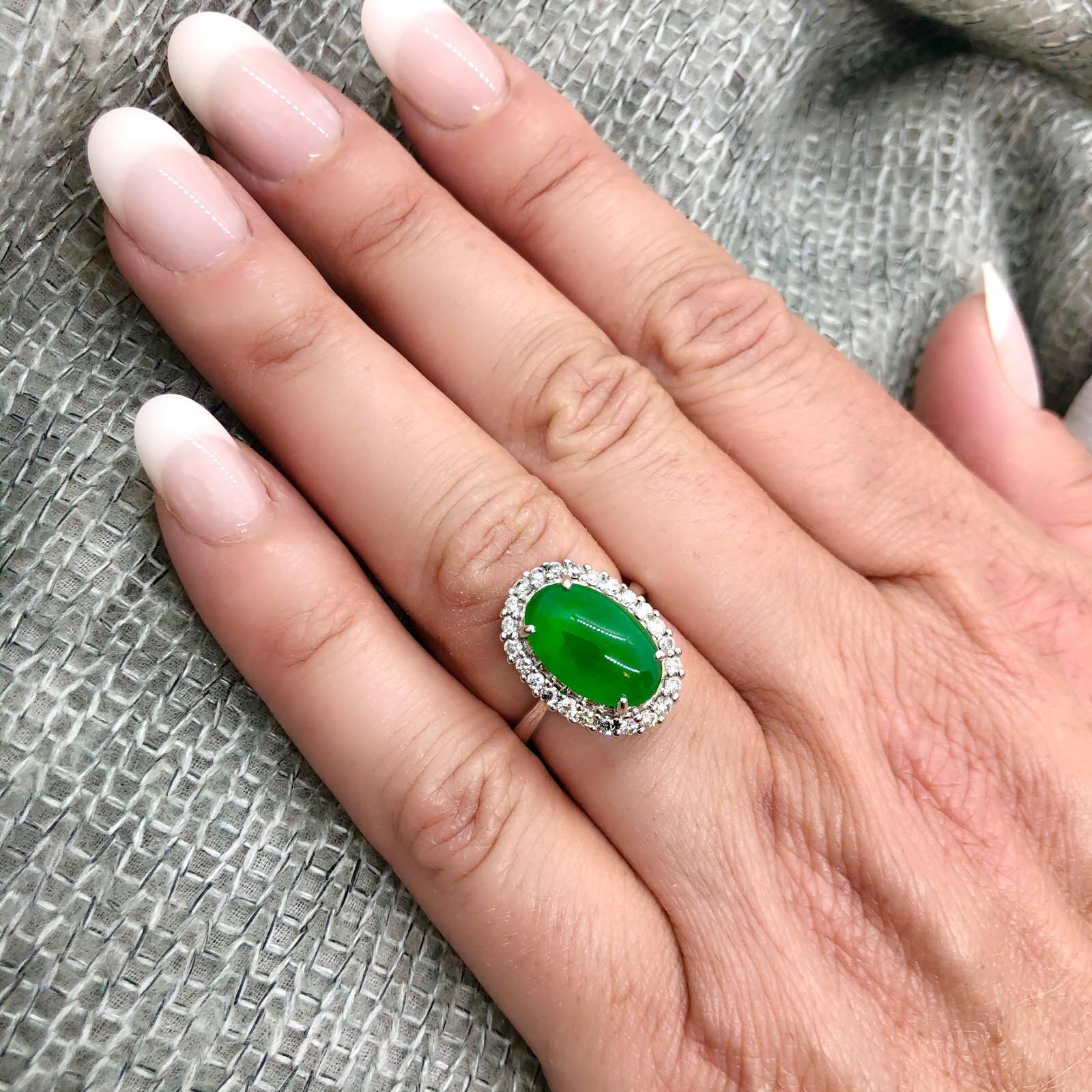 Estate 14Kt White Gold Oval Double Cabochon Cut Jade Ring set with 24 Round Brilliant Cut Diamonds for approximately 1ct. The total weight of the ring is 6.4 grams and is a size 6.75. Jade is natural with no indications of impregnation and GIA