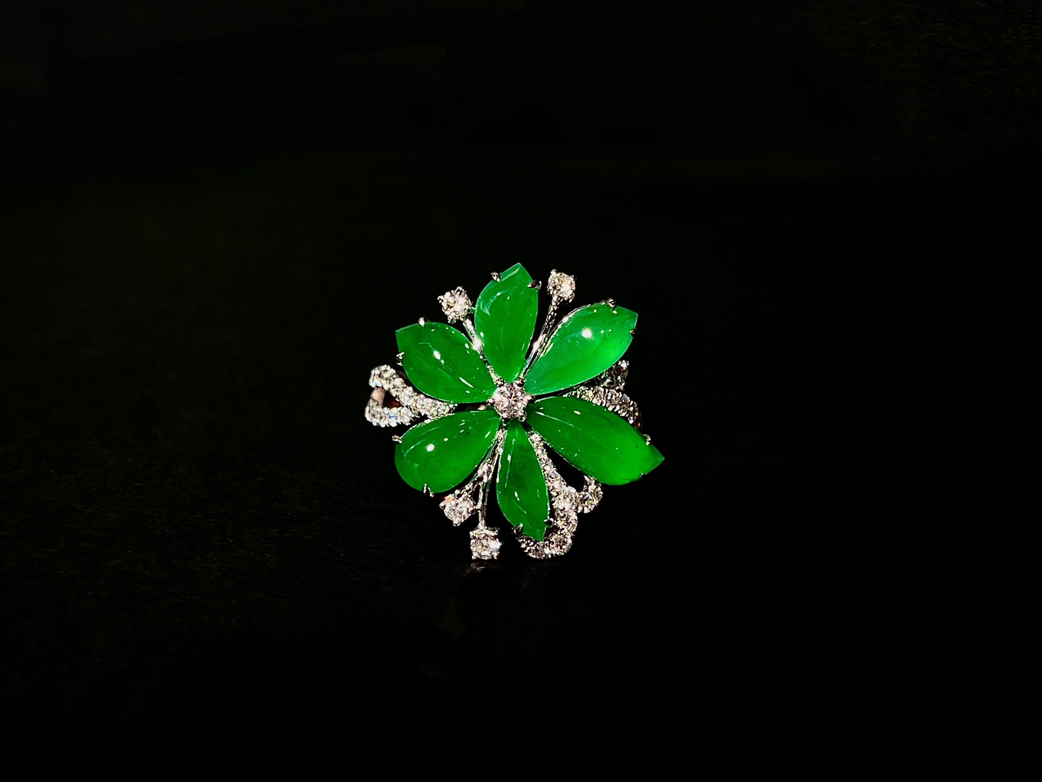 Questo eccezionale anello di giada naturale verde smeraldo a forma di petalo presenta una colorazione verde satura perfettamente uniforme, con trasparenza cristallina e brillantezza radiosa. Sapientemente incastonato in oro bianco da 18 carati,