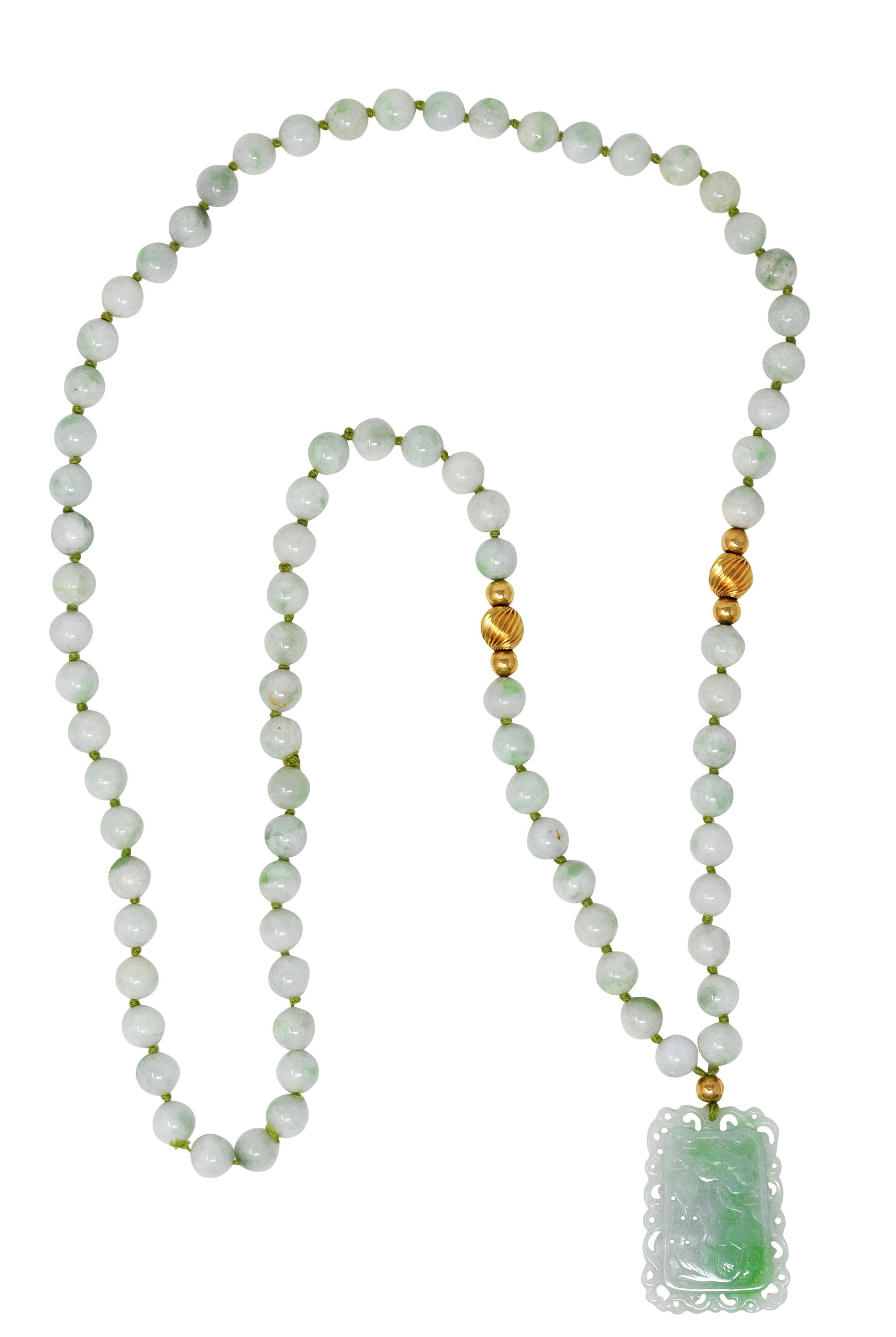 Design/One est une Corde de soie nouée, enfilée de perles rondes de jade de 9,0 mm et suspendue à un pendentif en jade sculpté. Vert bleuté très clair translucide avec des marbrures blanches et vertes moyennes - naturel sans indication