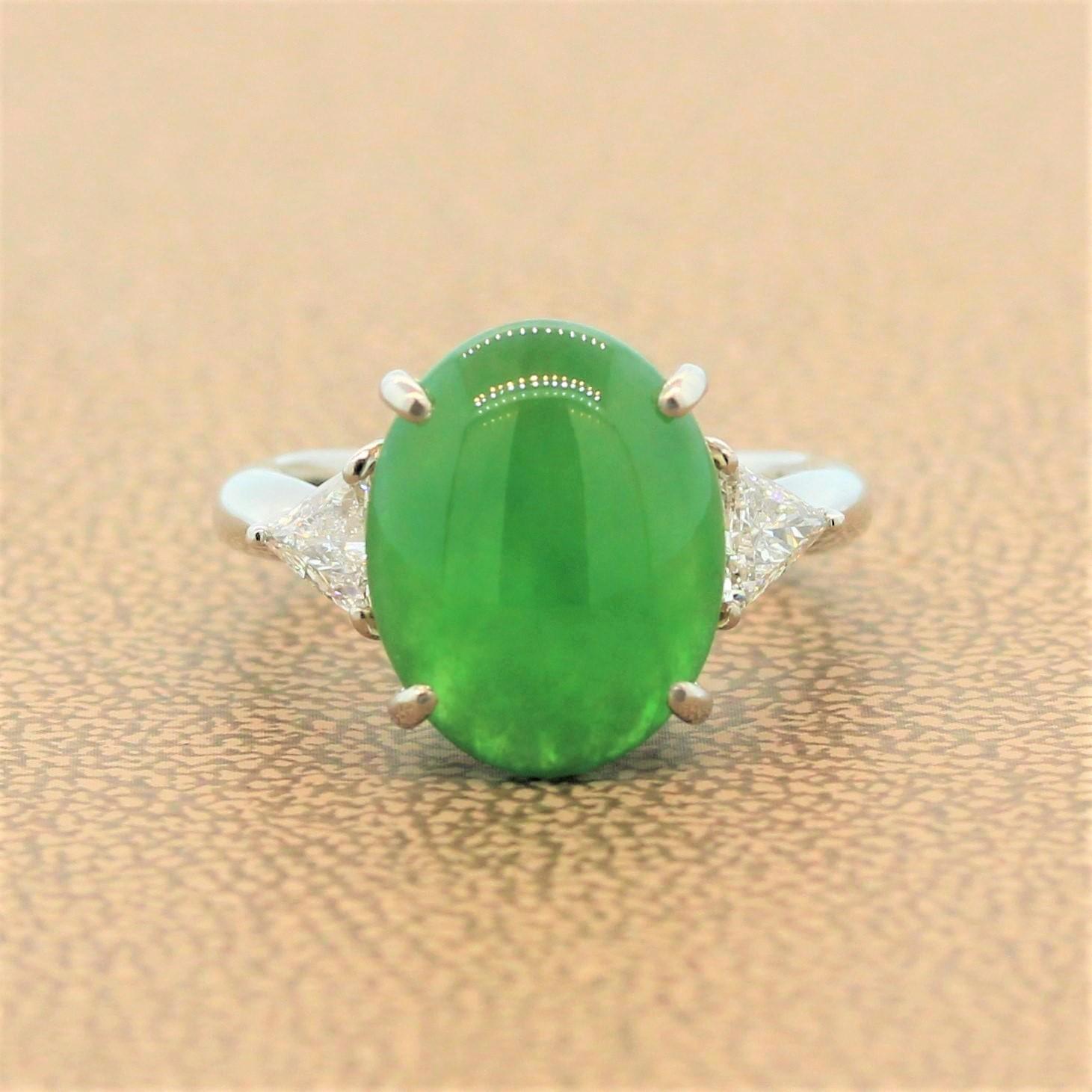 A clean design for this remarkable contemporary ring featuring an exquisite 5.00 carat piece of jade with lively color and strong luster. The oval cabochon green jade is embellished with 2 large trillion cut diamonds totaling 0.35 carats on the