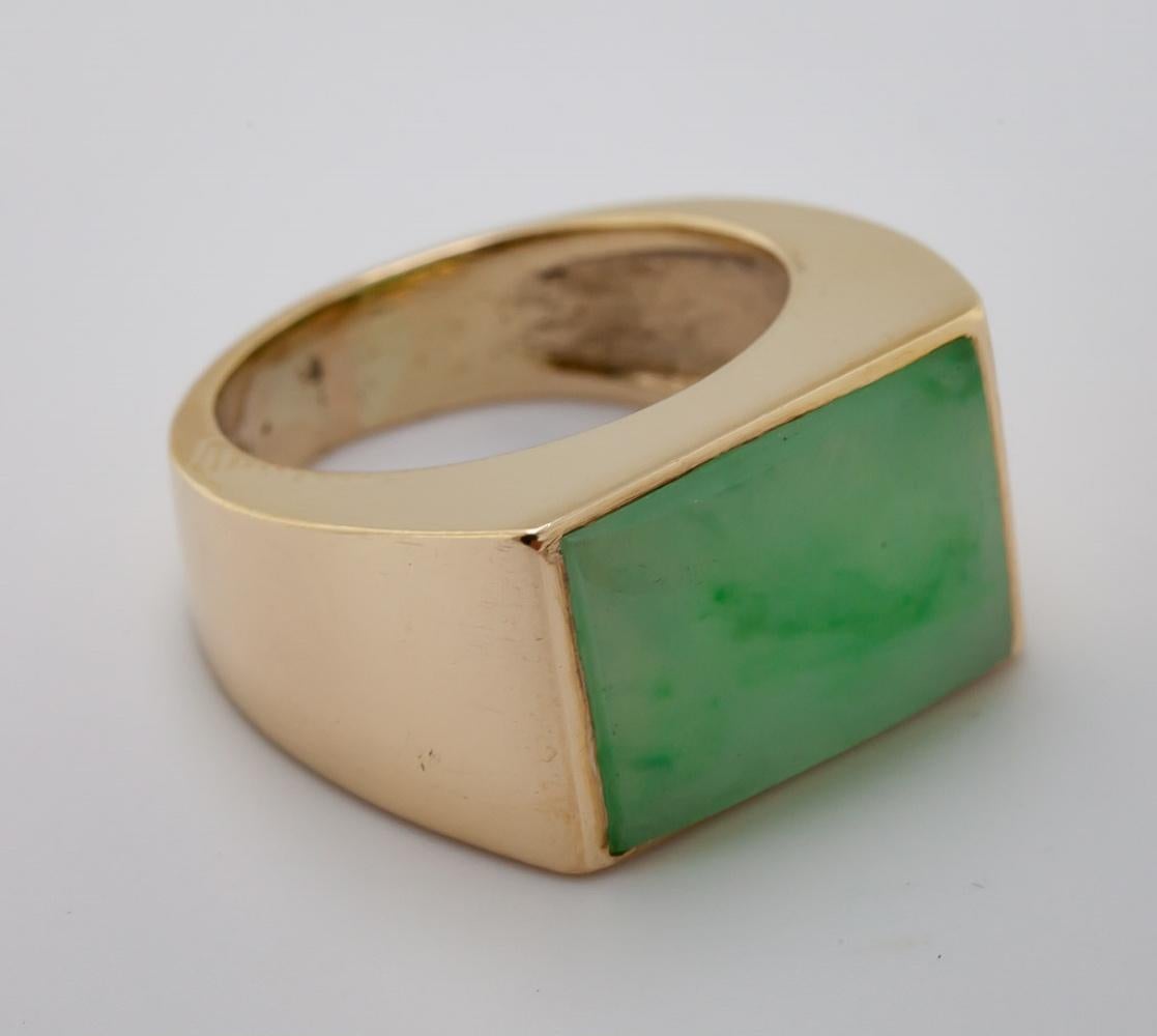 Featuring one mottled natural green, translucent raised tablet, 16.02 X 11.08 X 3.69 mm, accompanied by a Mason Kay Report, stating No Dye or Impregnation Detected – ‘A’ Jade,  bezel set in a 10k yellow gold ring, size 7.5, Gross Weight 11.5 grams.