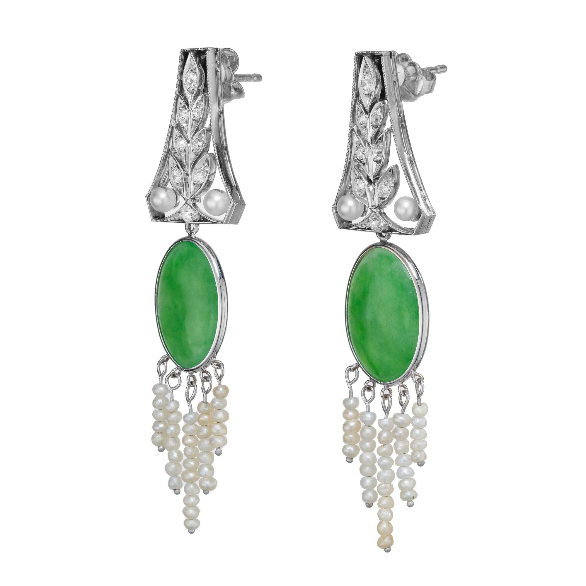 Unveil an era of 1930's elegance with our exquisitely crafted Jadeite Jade, pearl and diamond Art Deco platinum dangle earrings. Set with two oval jade tablets 3.54cts and 3.11cts that are mounted and framed in platinum. Both upper dangles are