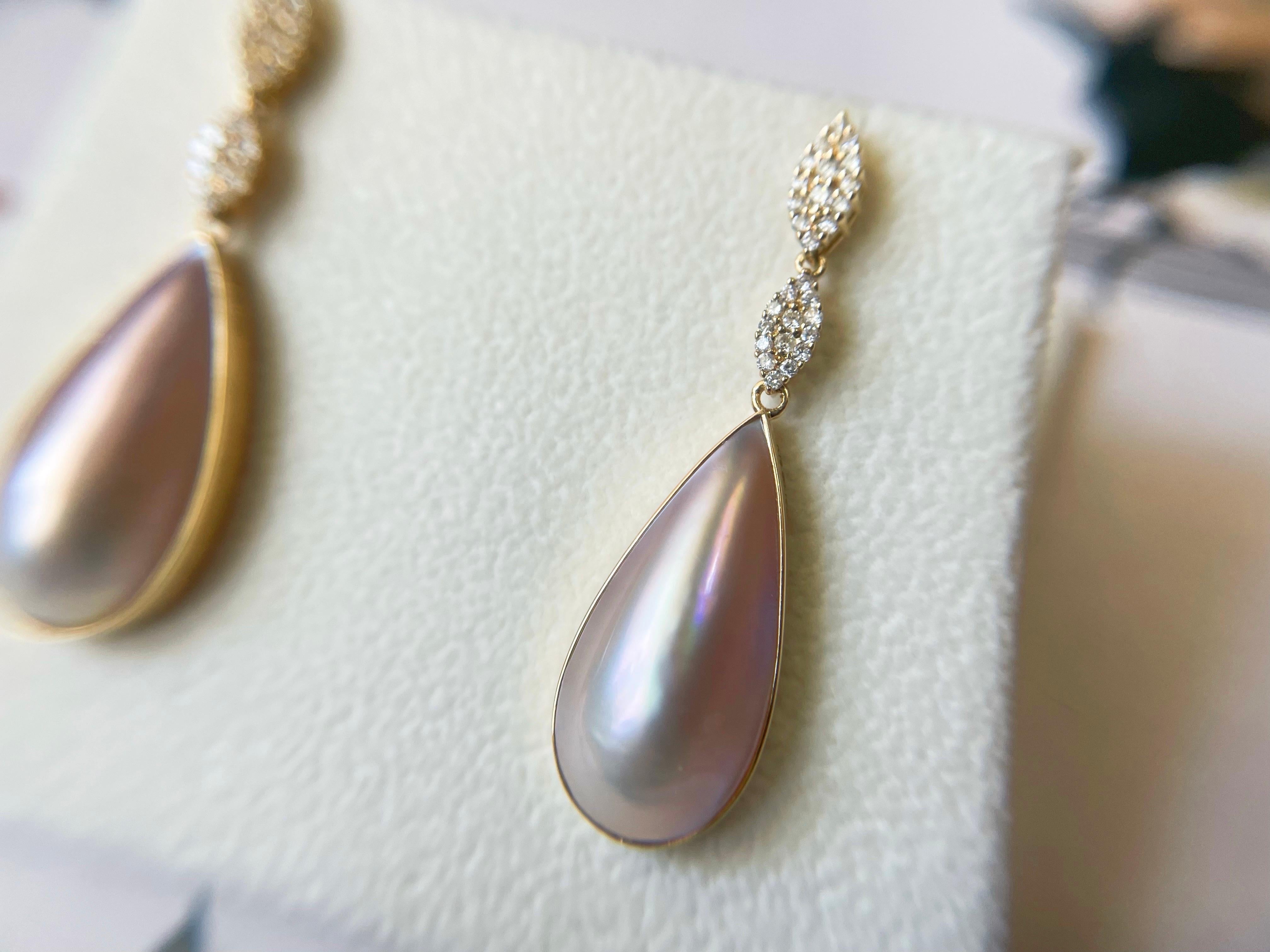Gönnen Sie sich Luxus mit diesen atemberaubenden Mabe-Perlenohrringen von der japanischen Insel Amami. Die irisierenden rosafarbenen Perlen mit goldenem Schimmer sind eine Augenweide, und die 18-karätige Goldfassung und die Brillanten machen sie