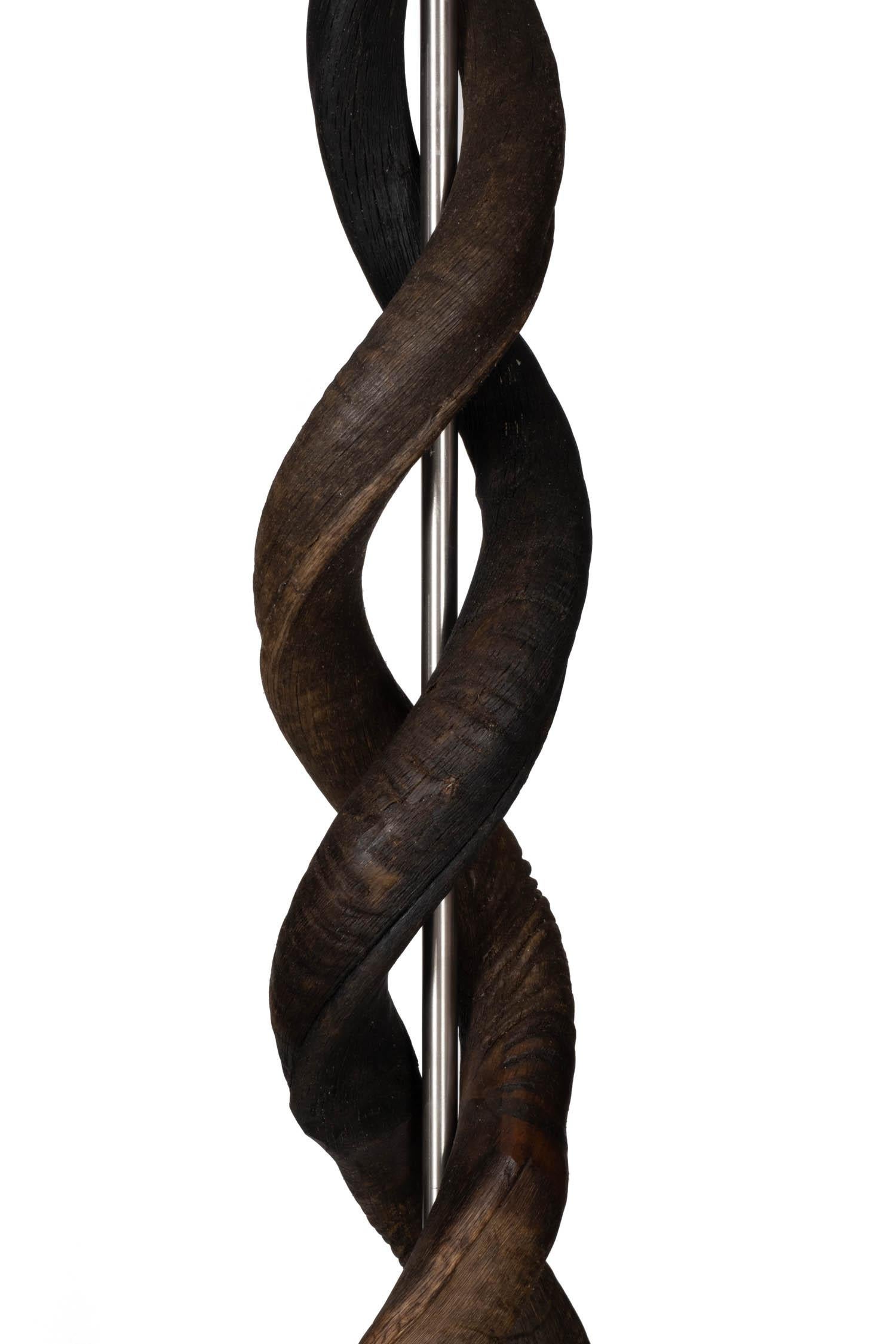 Fabriqué à la main en Afrique du Sud, ce lampadaire d'une élégance naturelle présente quatre cornes naturelles de koudou africain entrelacées qui semblent suspendues au-dessus d'une base en bois enveloppée d'une peau de gnou surpiquée. . Toutes les