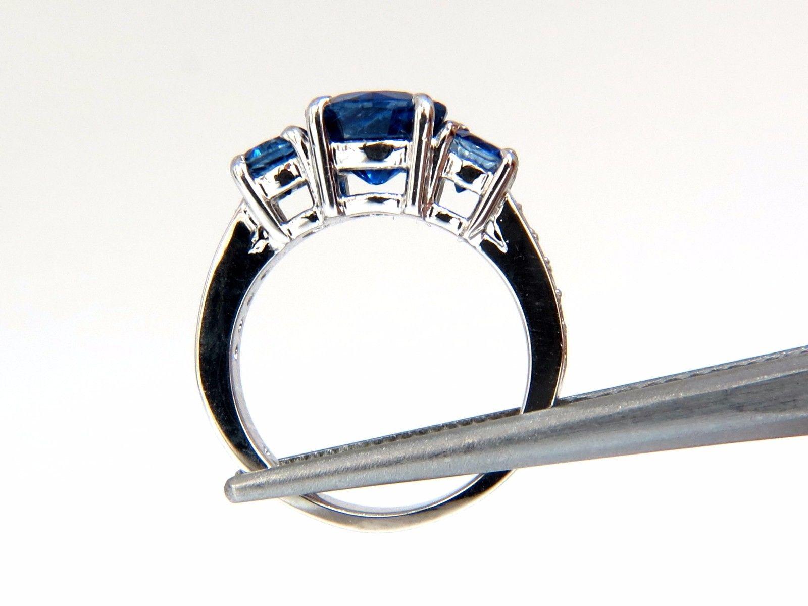 Kyanite Blues, Classic Three's

2.60ct natural Round cut Kyanite ring.

Vibrant vivid blue

Transparent & clean clarity.

7.95mm diameter

.94ct. (2) natural sapphires on sides

Side diamonds:

.20ct  round & full cuts.

G-color Vs-2 clarity.

14kt