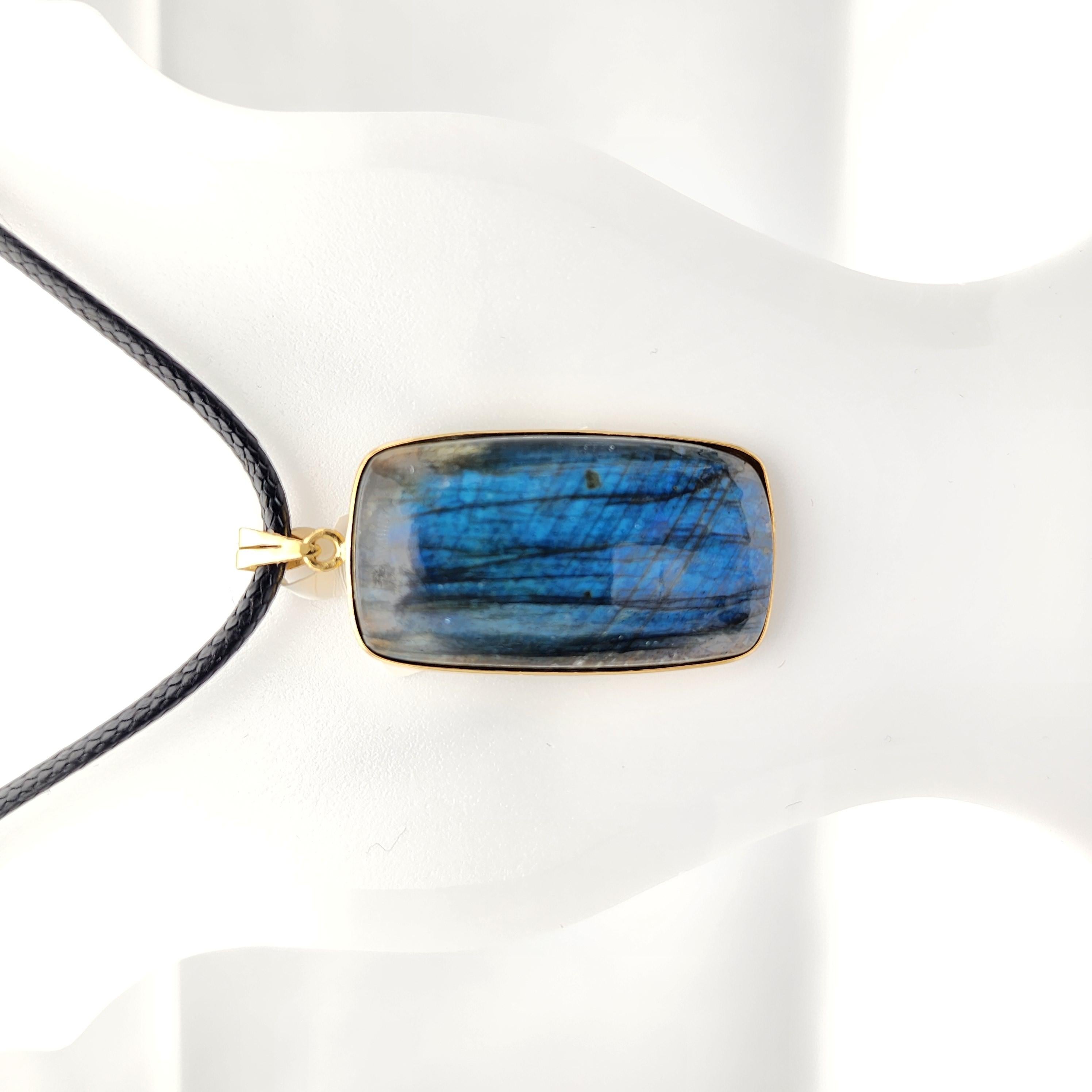 Natural Labradorite Pendant 

Features beautiful deep blue flash 
Unique keystone Long Octogen shape
This Stone has Known to bring stability and protection to the wearer. 
Handmade with solid Sterling Silver and 14K Yellow Gold Platting.
Each unique