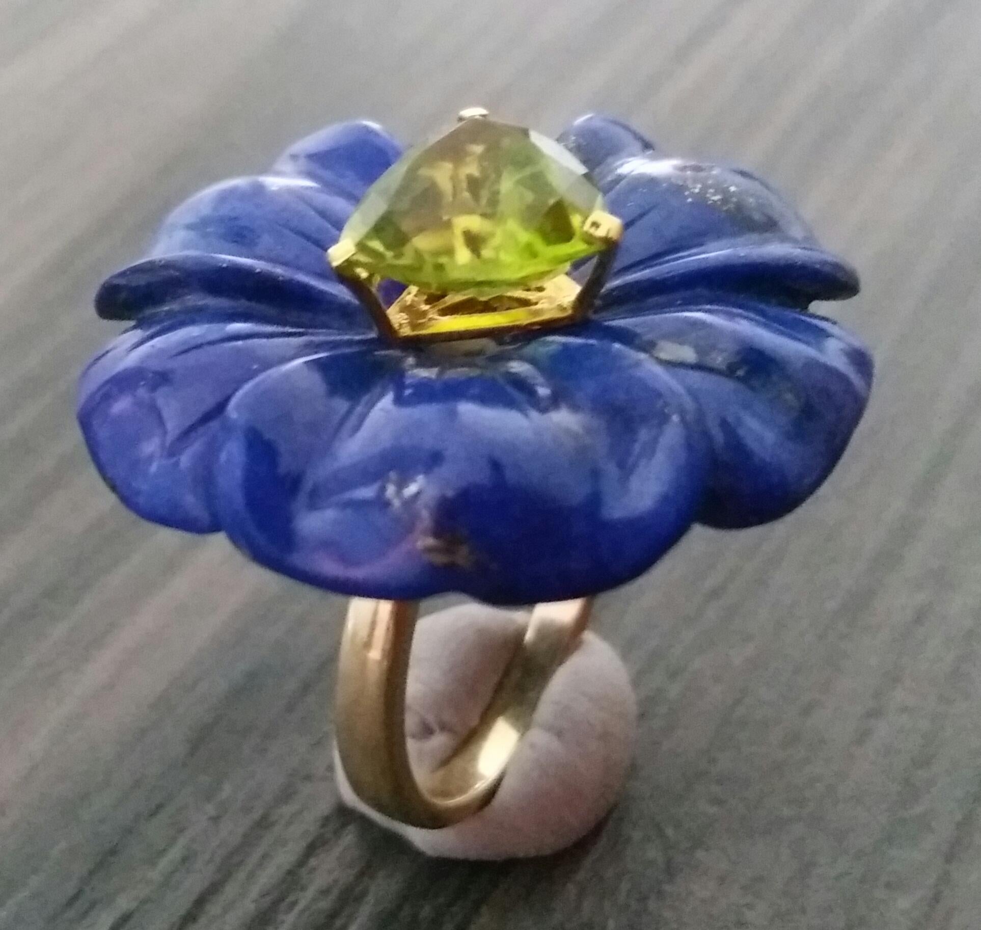 Flower carved Natural Lapis Lazuli of 30 mm. in diameter  with in the center a Trillion Cut Peridot 10 mm size set in solid 14 Kt yellow gold  is mounted on top of a 14 Kt. yellow gold shank. US size # 7 (but resizable according to client