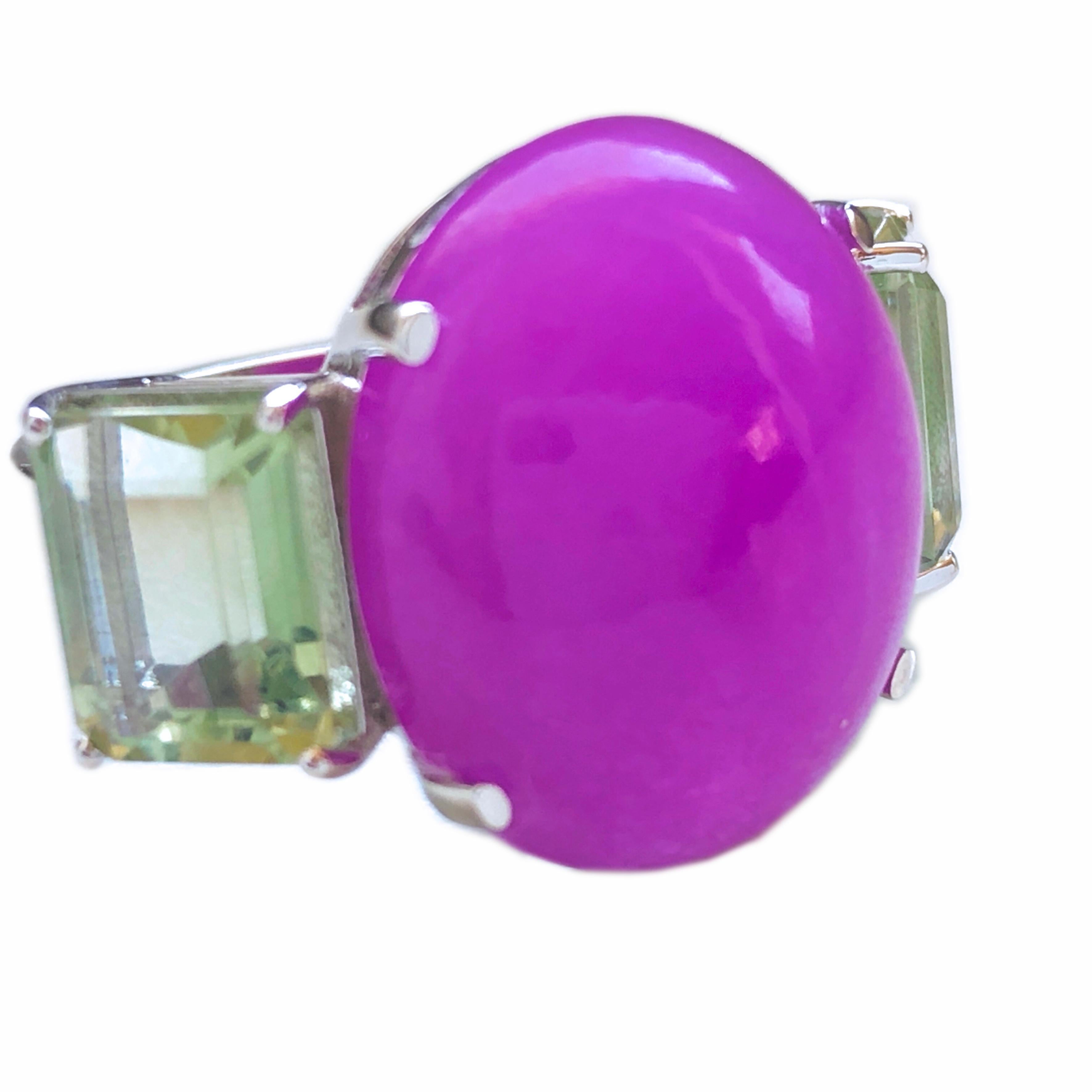 One-of-a-kind Chic and Glamorous Contemporary Cocktail Ring featuring an 11.70 Carat Natural Oval Cabochon Lavender Jade surrounded by two 3.79 Carat Light Green Sage Prasiolite(green amethyst) Emerald Cut. 
In our fitted Burgundy Leather Case.
A