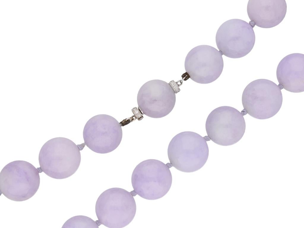 Natural lavender jade bead necklace with diamond set clasp, circa 1950. A necklace composed of thirty three untreated lavender jade spherical beads measuring approximately 13.9 mm to 15.1 mm in diameter, one bead forming the clasp and set one either