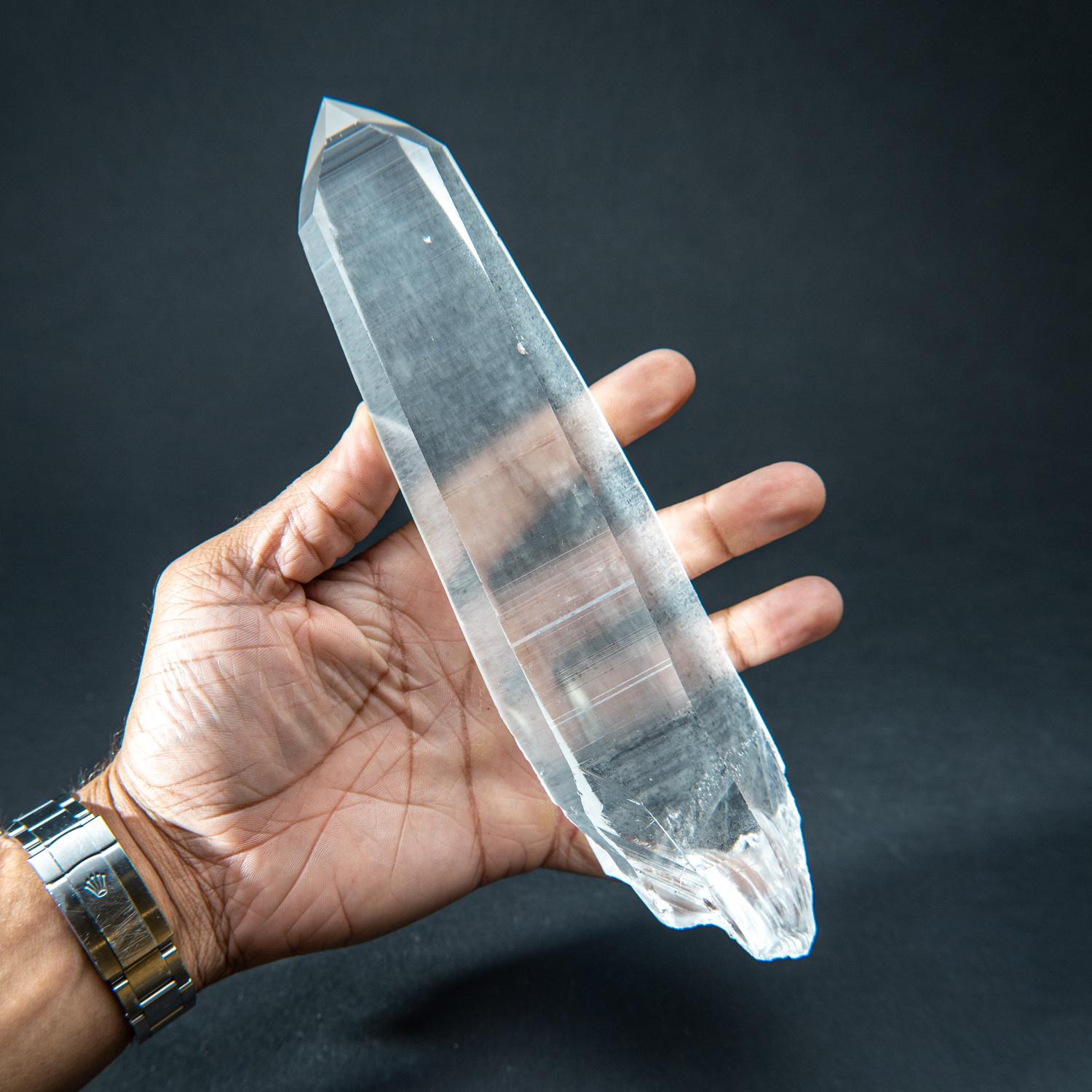 This natural 1.65 lb Brazilian Lemurian Quartz is a large single specimen, featuring transparency and an intact termination. No damage is present, and the crystal is unpolished. Clear Quartz is famously known as the 
