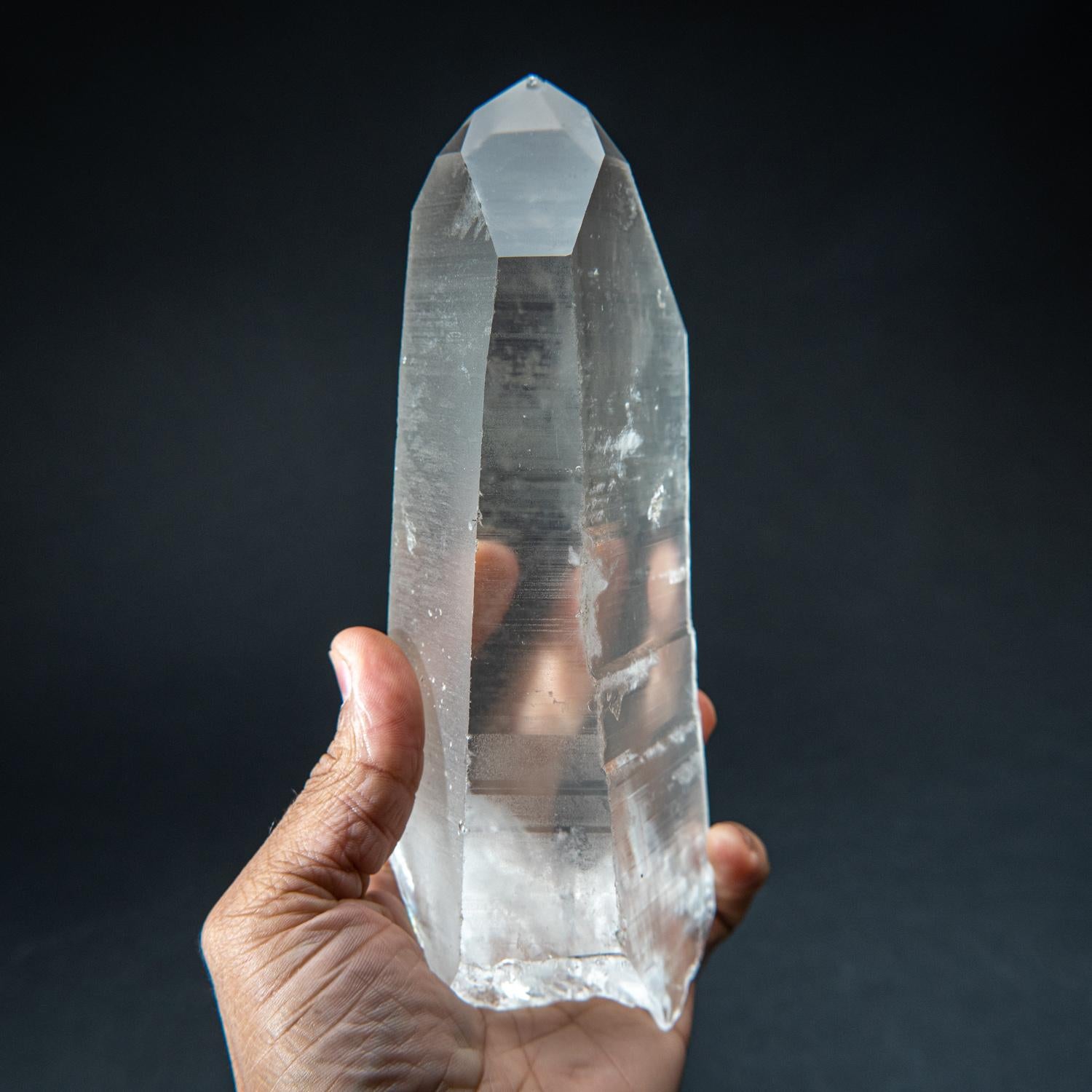 This natural 2.75 lb Brazilian Lemurian Quartz is a large single specimen, featuring transparency and an intact termination. No damage is present, and the crystal is unpolished. Clear Quartz is famously known as the 