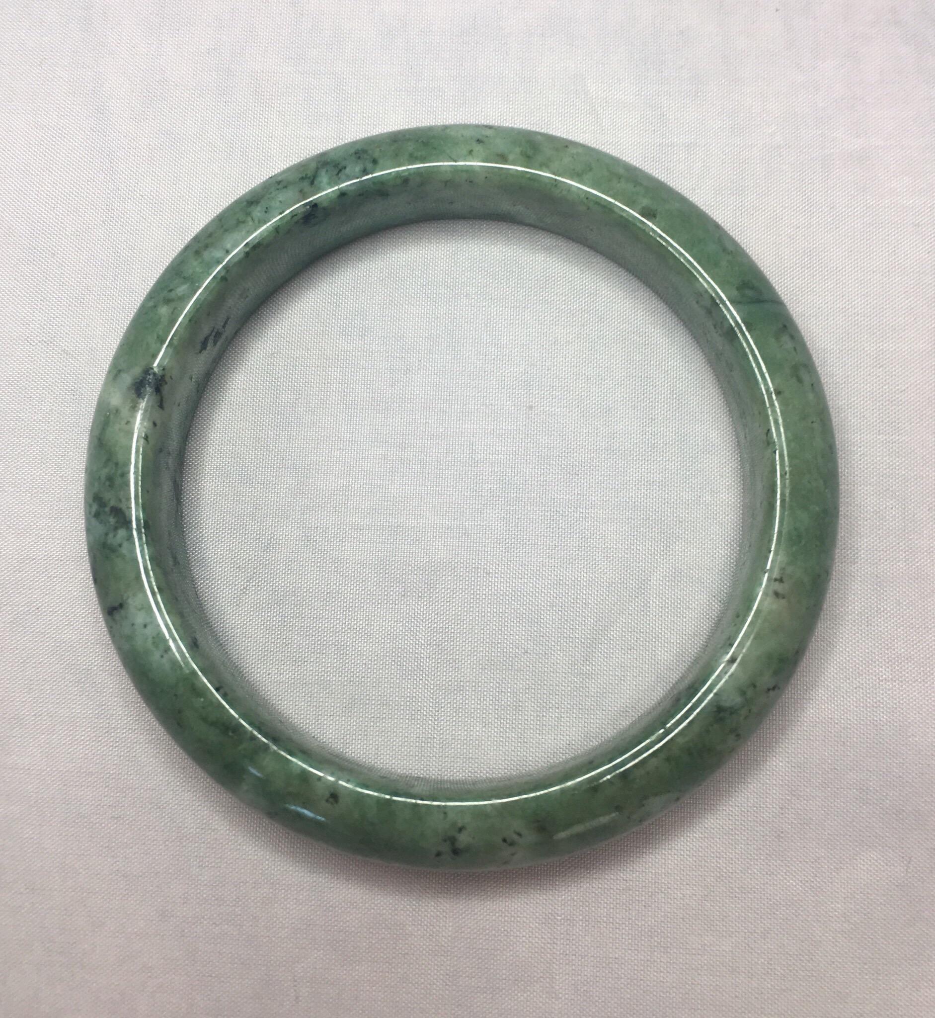 Beautiful natural light green jadeite jade bangle.

Has a beautiful mottled light green colour with an excellent polish and lustre with no cracks or chips.

This is a treated jadeite bracelet, as to be expected of such a large piece in this price