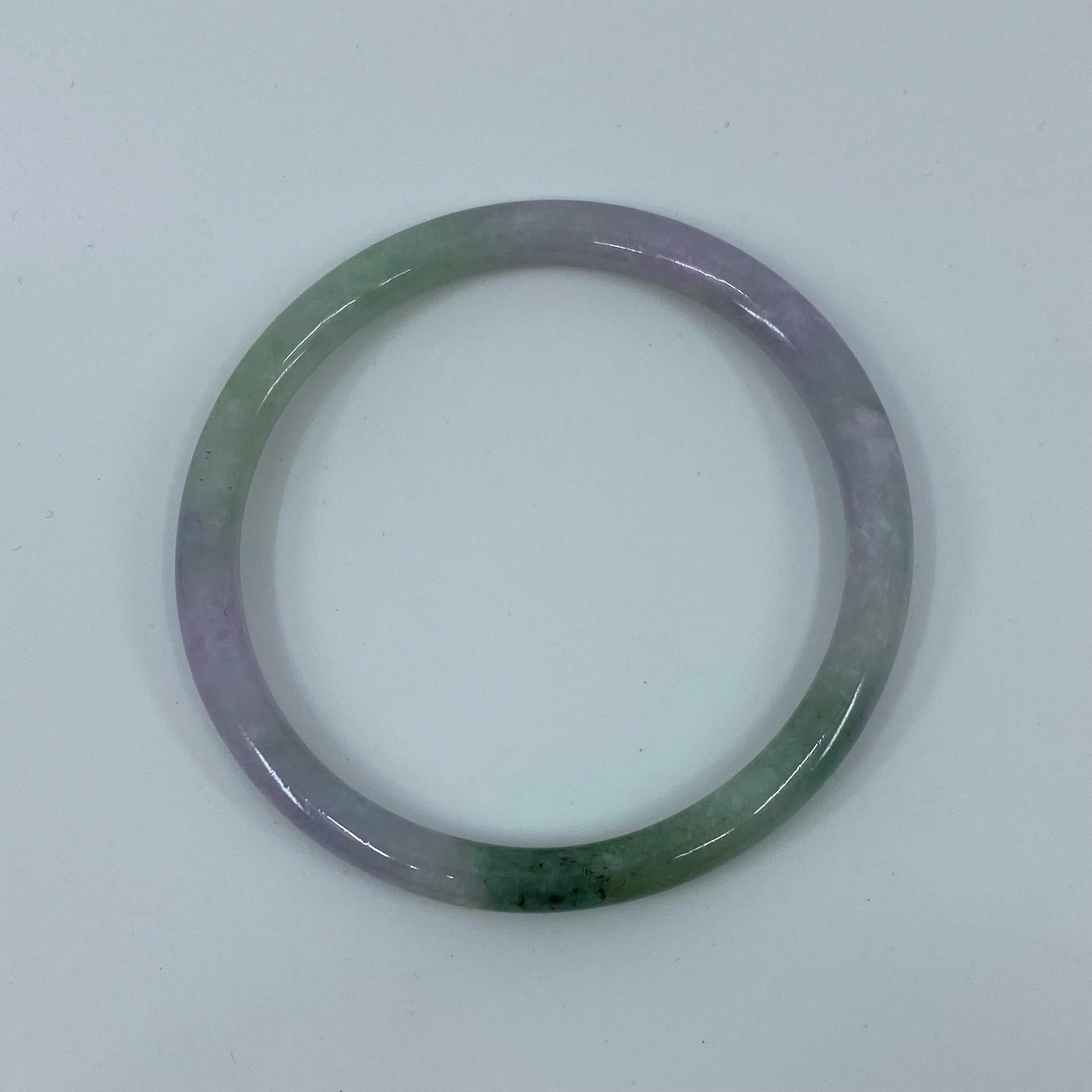 Beautiful natural light green purple/violet jadeite jade bangle.

Has a beautiful mottled light green purple violet colour with an excellent polish and lustre with no cracks or chips.

This is a treated jadeite bracelet, as to be expected of such a