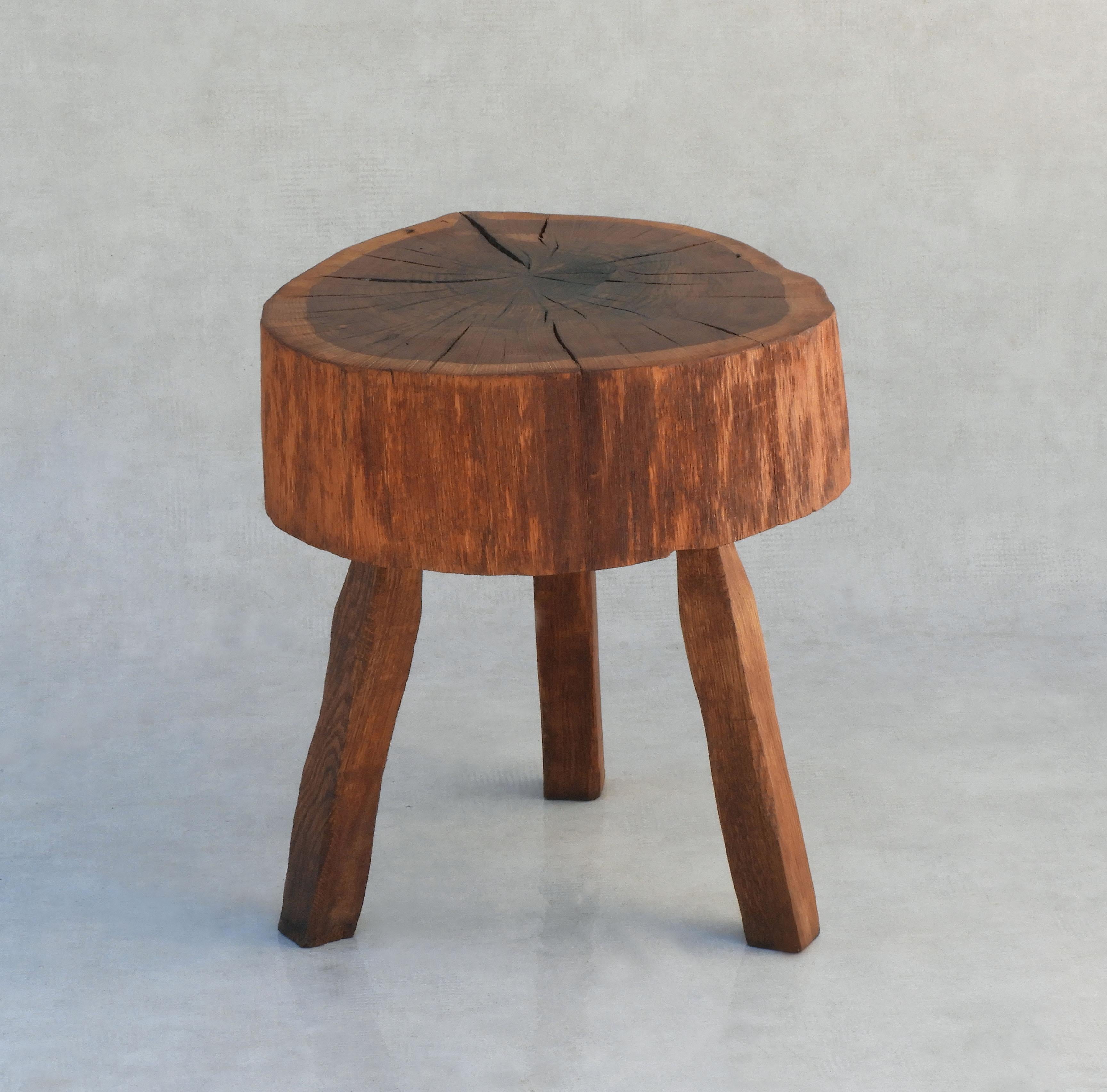 Organic three-legged tree slab table handcrafted in France, circa 1970.  Well made, heavy, solid and sound with no hardware. Live edge, good grain, great colour and patina.  A really nice example of handcrafted French 'Arte Populaire' in great