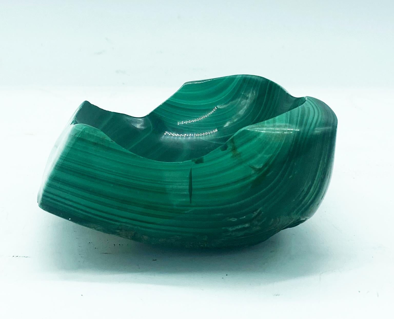 Decorative bowl or ashtray fashioned out of a piece of all natural malachite mineral stone. Polished beautifully to display the natural layerings and concentrics of the stone.
 