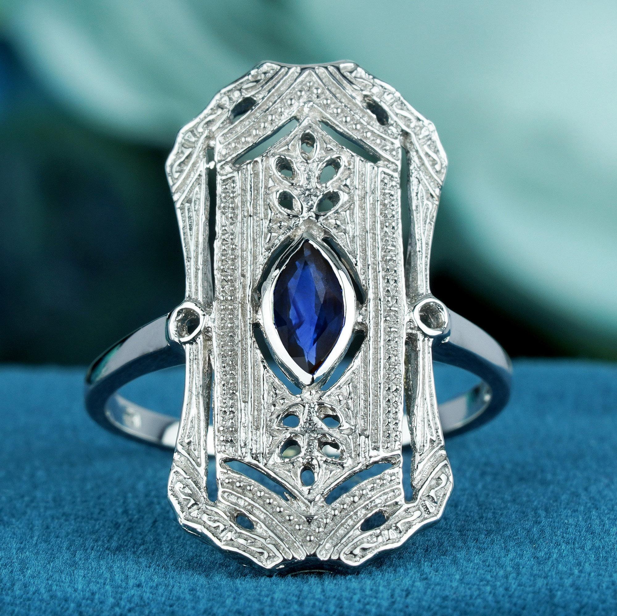 Laissez-vous séduire par l'élégance intemporelle de notre bague de table de style art déco en saphir bleu naturel, en or blanc massif. Cette pièce exquise est ornée d'un saphir de forme marquise, magnifiquement serti dans une lunette sécurisée. Le