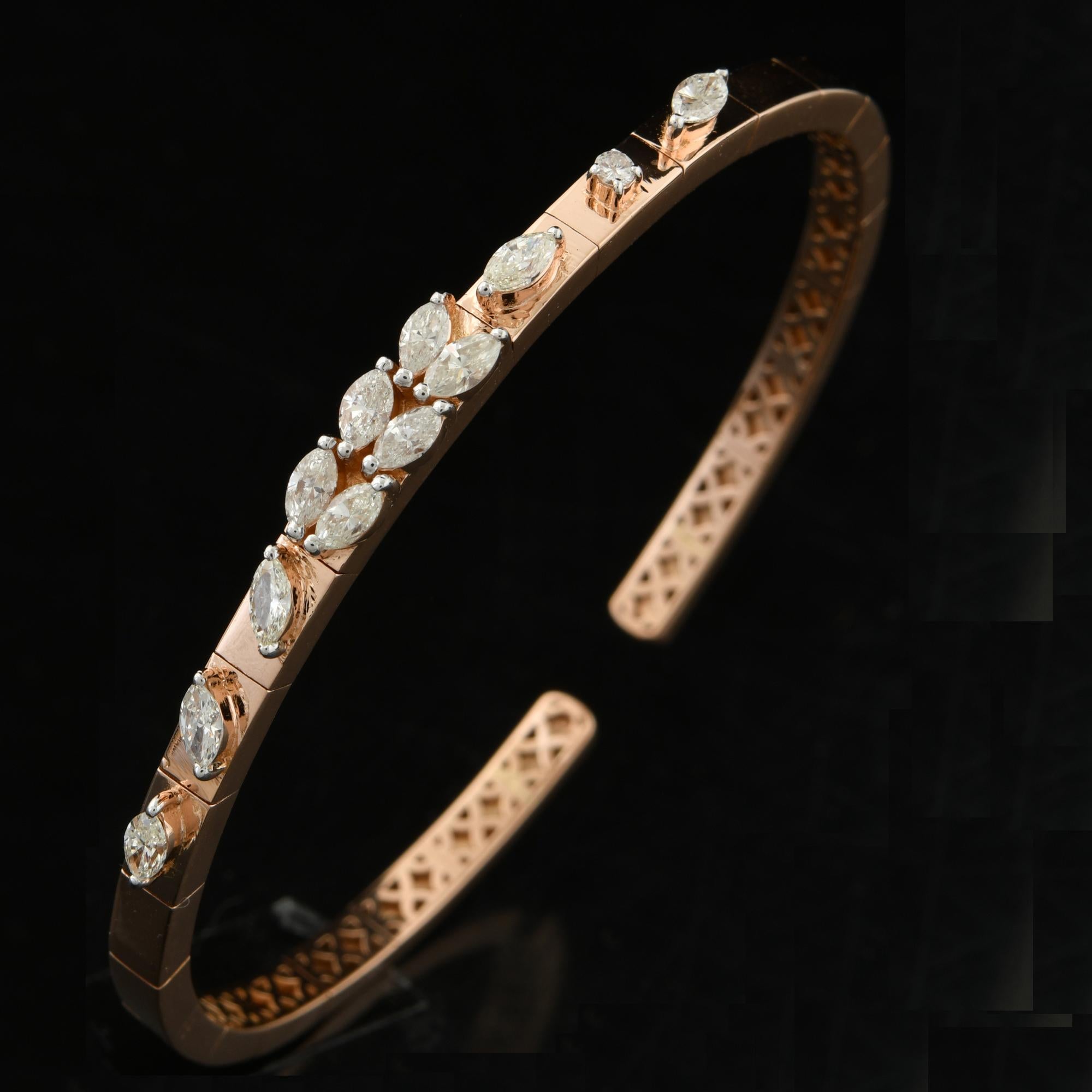 The bracelet features a sleek and modern design, with a cuff-style bangle that gracefully wraps around the wrist. The bangle is crafted from high-quality 14 karat yellow gold, renowned for its rich and warm hue. The gold has been expertly polished