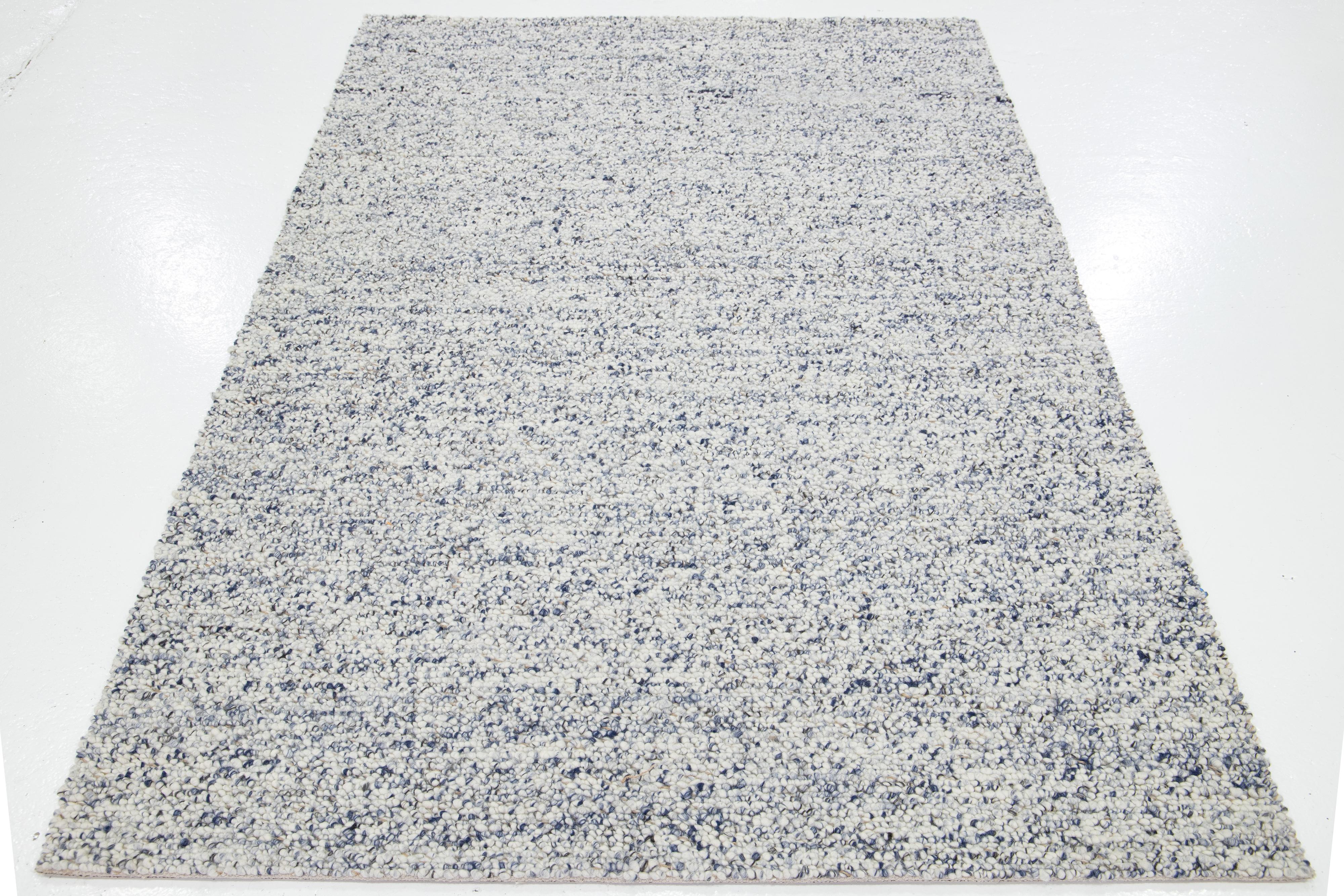 This beautiful Felt hand-woven wool rug is part of our Westport Collection. It has an ivory field with blue accents throughout the geometric design.

This rug measures 5' x 8'.

Custom colors and sizes are available upon request.

