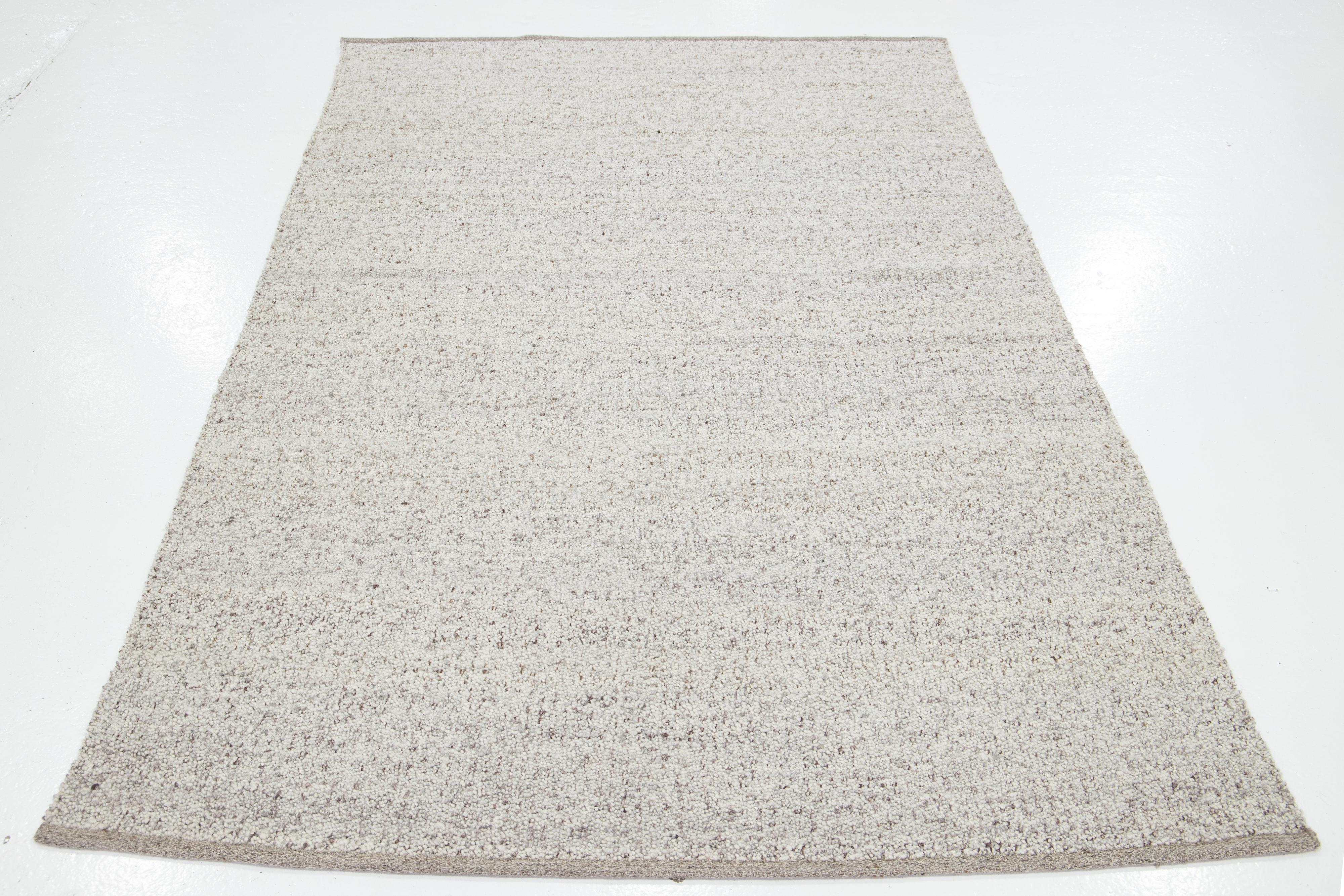 Questo bellissimo tappeto in lana Felt, tessuto a mano, fa parte della nostra Collectional Westport. Ha un campo avorio con accenti grigio chiaro e marroni in tutto il disegno della texture.

Questo tappeto misura 5' x 8'.

Colori e dimensioni