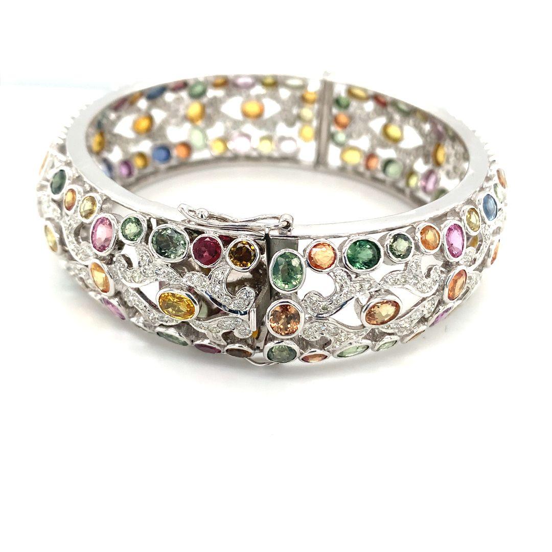 Stunning 18 Kt white gold bangle adorned with 15.50 carats of multi-sapphire gemstones and 3.50 carats of diamonds.

