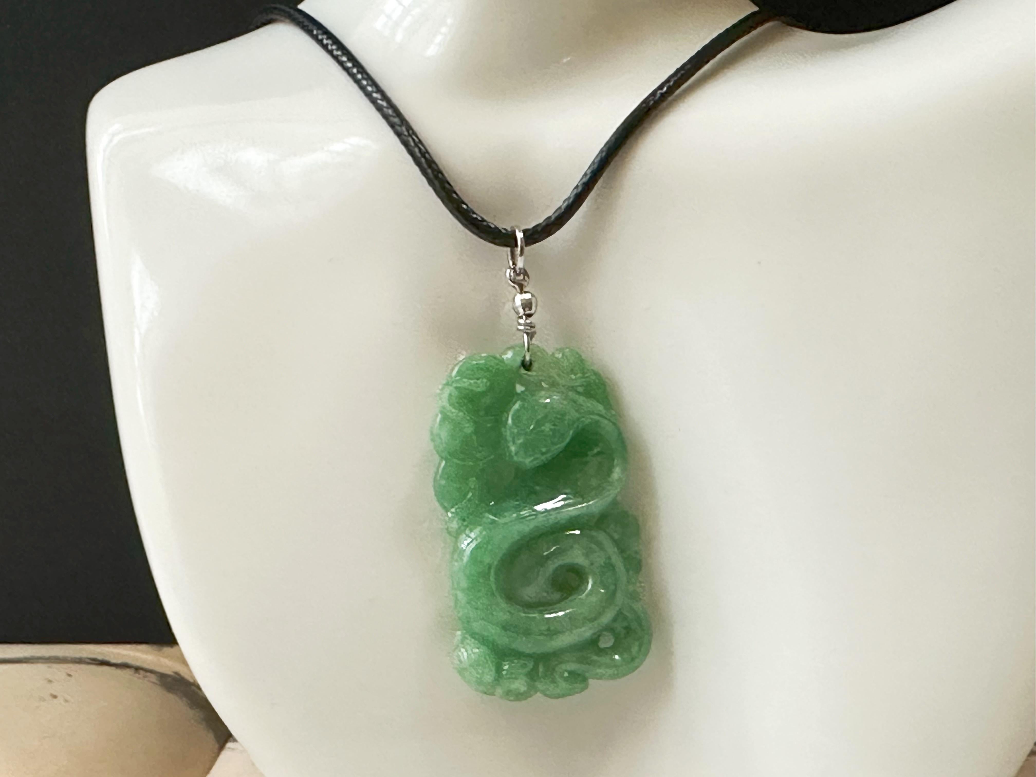 This jade pendant is 100% natural, untreated, and undyed Type-A Myanmar jadeite jade. It is hand-carved into a snake and ancient coins. The beautiful apple green color Mother Nature gifted makes this pendant unique and attractive. This pendant has a