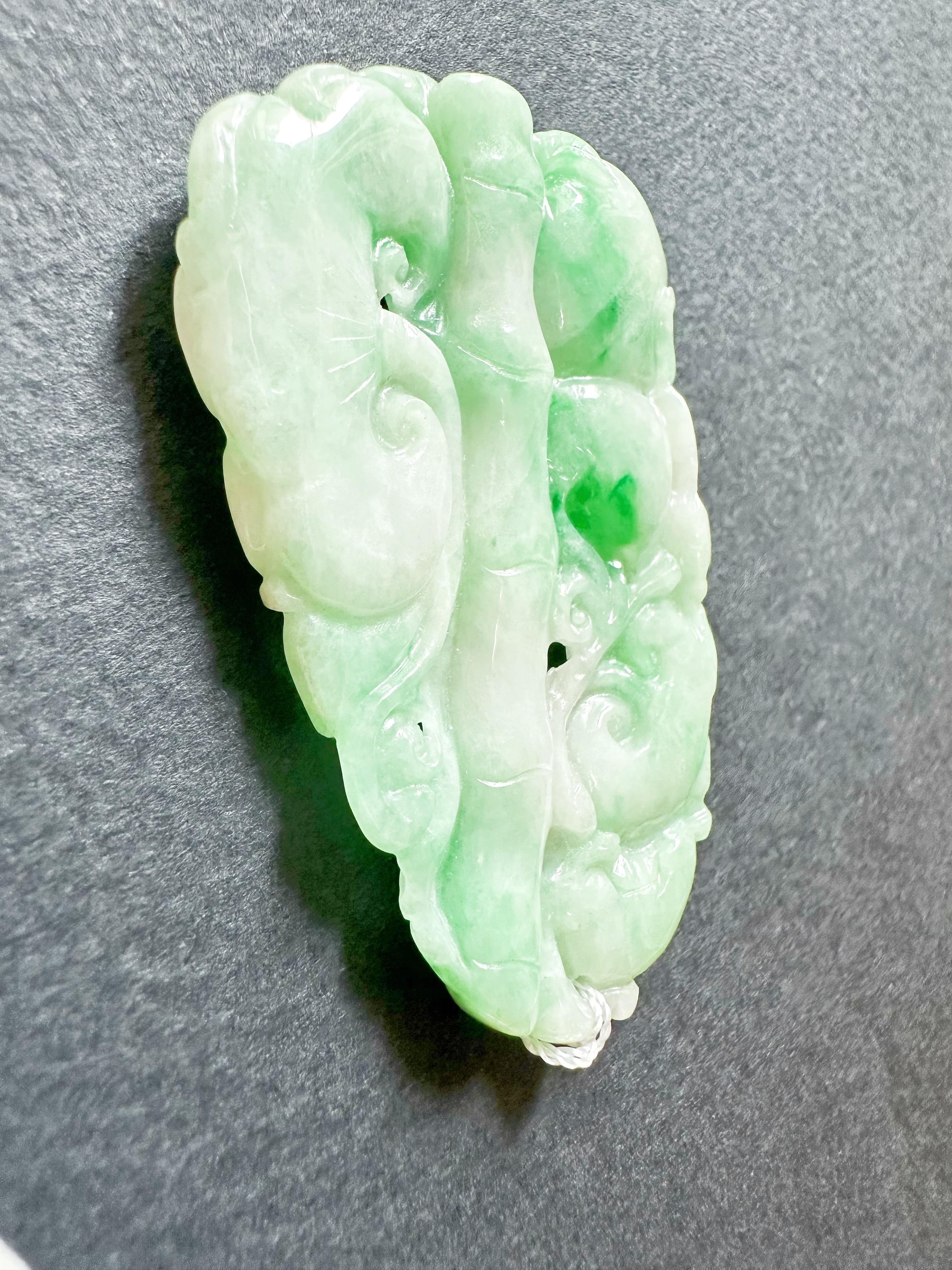 Nous vous présentons notre pendentif en bambou, ruyi et pêche sculpté en jade vert vif du Myanmar naturel, une superbe pièce de jade à double face qui met magnifiquement en valeur l'art complexe de la sculpture du jade. Ce pendentif exquis présente