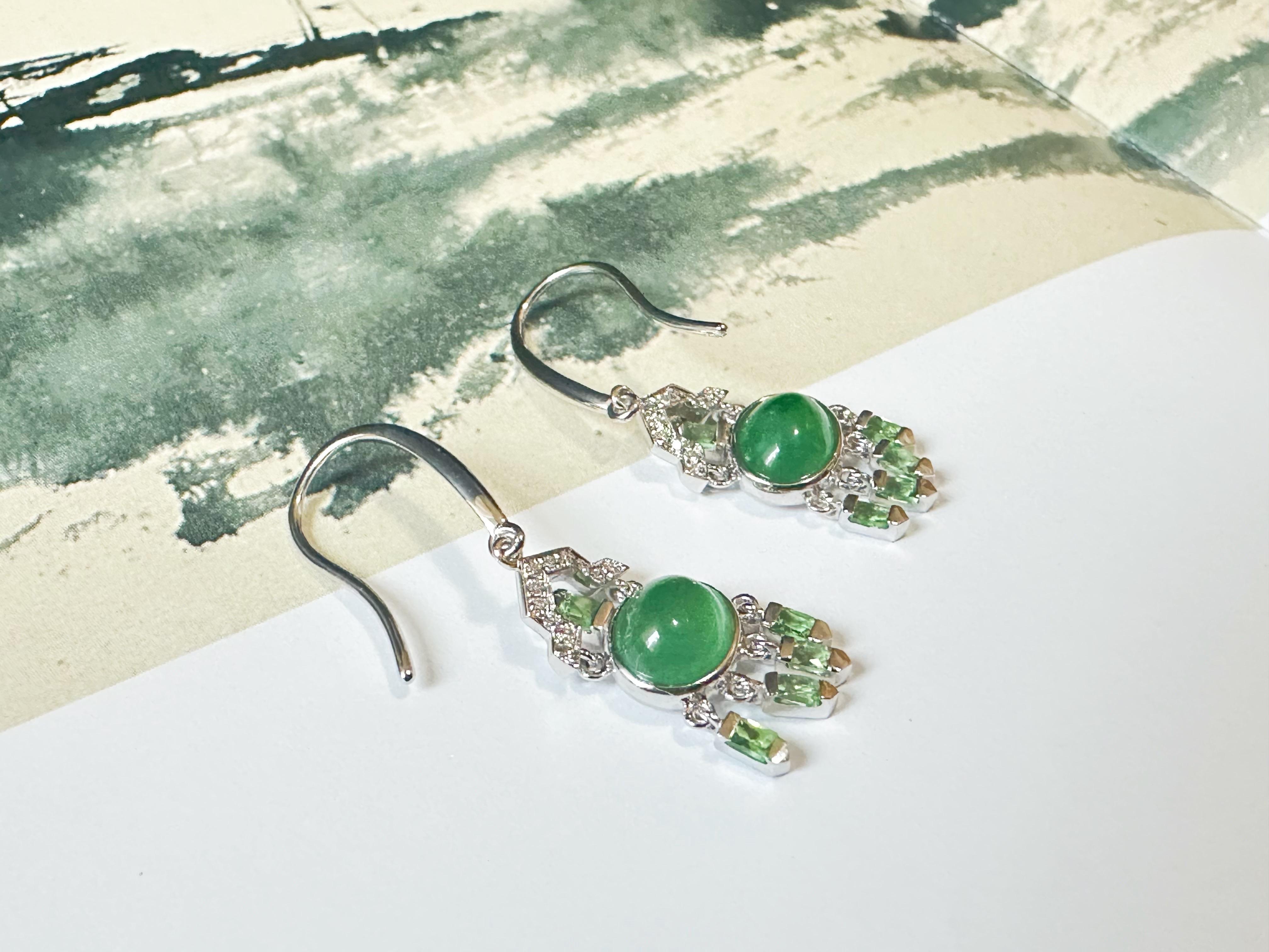 Discover our stunning Natural Myanmar Icy-Type Green Jade Cabochon Earrings, crafted in 18K gold and accented with diamonds and tsavorite.

These exquisite jadeite gemstones, sourced from Myanmar, showcase a captivating icy green color and natural