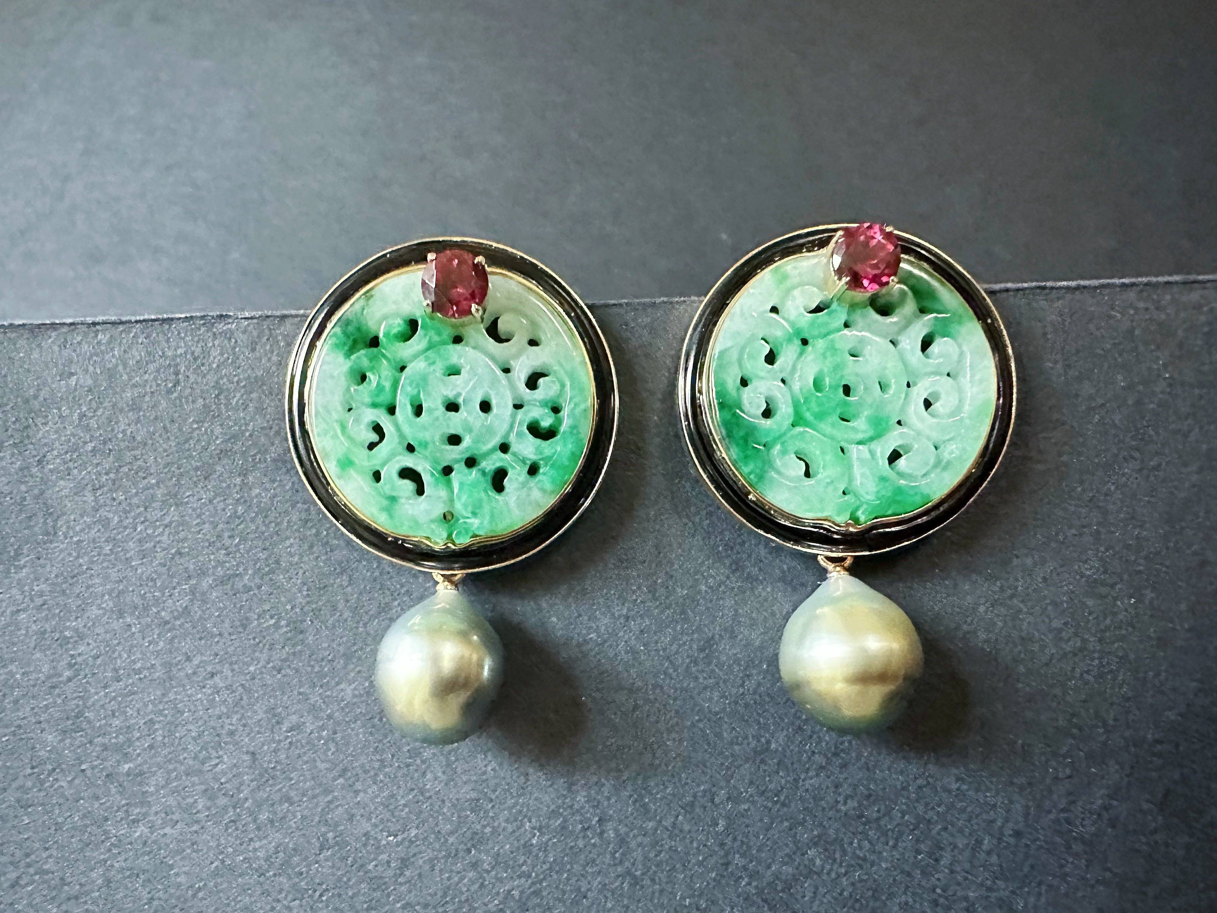 Indulge in the epitome of luxury with these handcrafted earrings, featuring stunning round jade carved from rich green Myanmar jadeite. Set against a backdrop of elegant black agate and framed in 18K gold, these earrings are not just accessories but