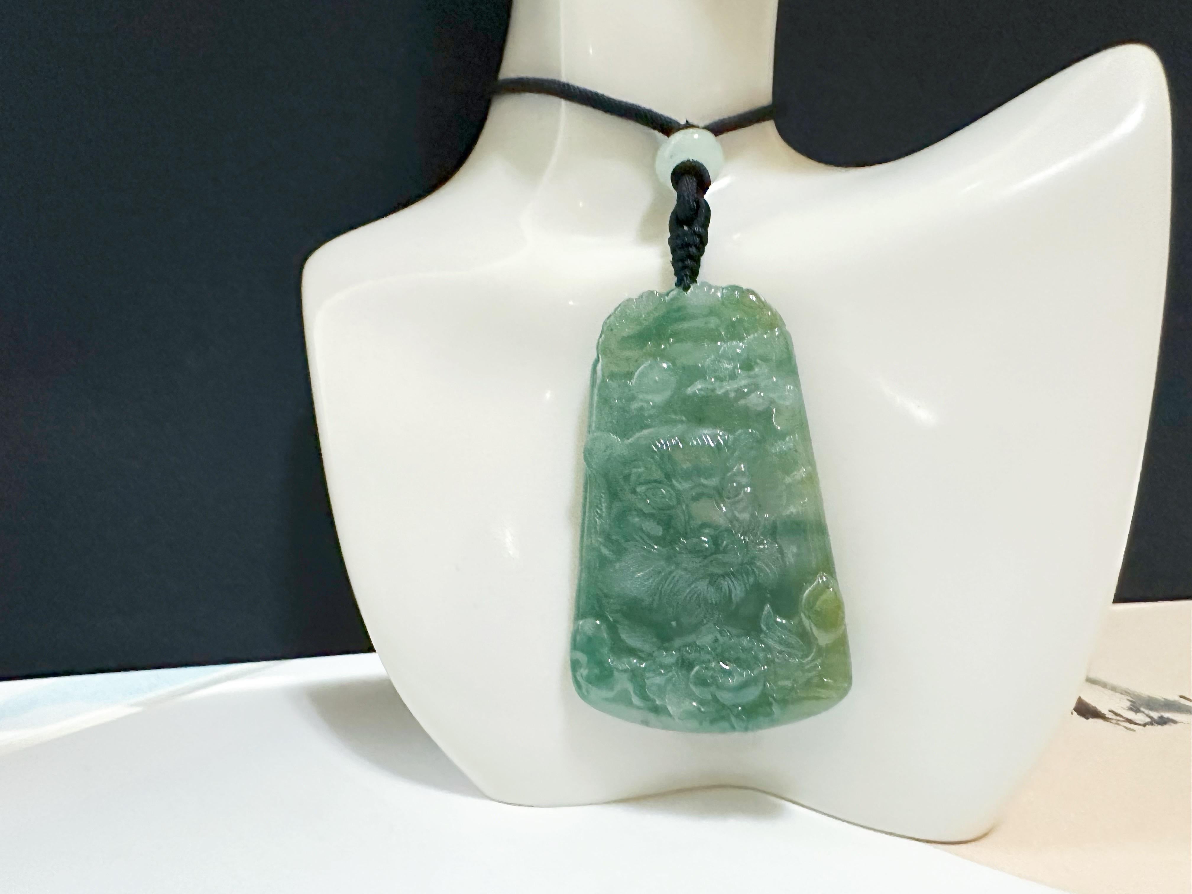 Ce pendentif en jade est 100 % naturel, non traité et non teinté en jadéite de type A du Myanmar. Il est sculpté à la main d'un tigre, de fleurs et de Keishi. La magnifique couleur vert bleuté et la texture de type glacé offertes par Mère Nature