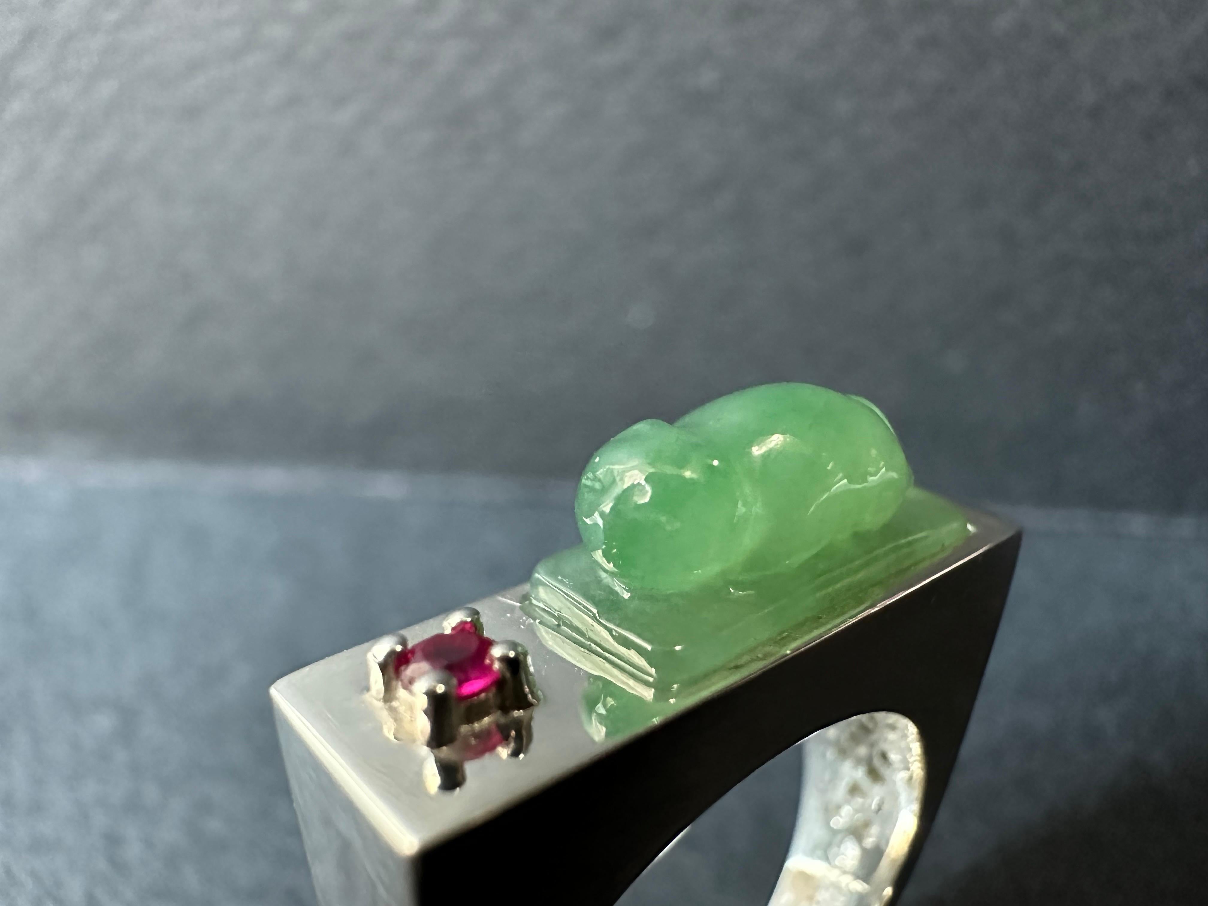 Introducing our exquisite, handcrafted Cat Jade Ring, featuring a captivating design of a cat lying flat. This stunning piece showcases the elegance of a hand-carved jade stone set in high-quality silver.

Our talented artisans have carefully