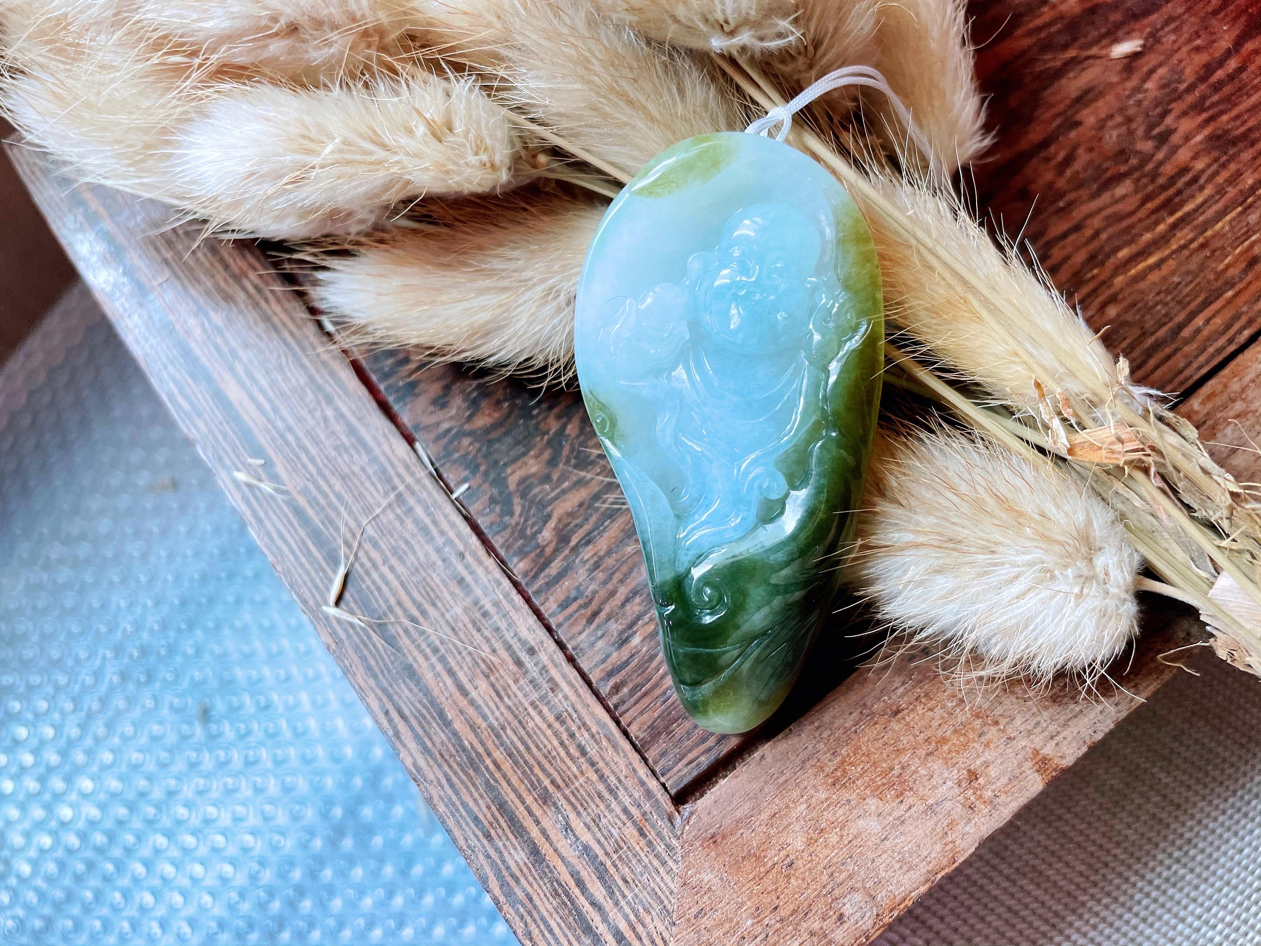Dieser Jade-Anhänger besteht zu 100% aus natürlicher, unbehandelter und ungefärbter Jade vom Typ A aus Myanmar. Er ist handgeschnitzt als Happy Buddha. Mutter Natur schenkte diesem Anhänger eine wunderschöne, durchscheinende, eisige Textur mit