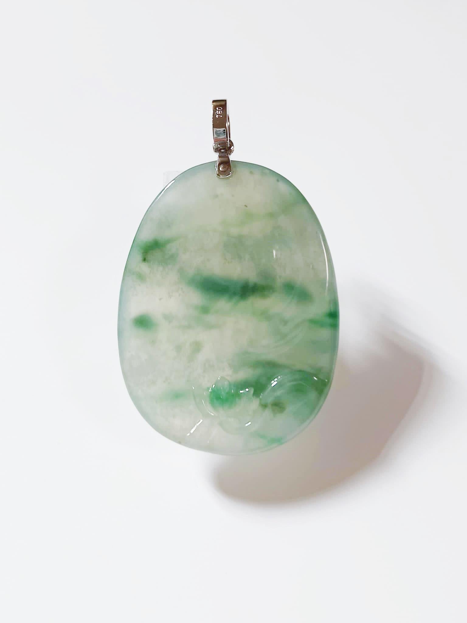 Ce pendentif en jade est 100 % naturel, non traité et non teinté en jadéite de type A du Myanmar. Il est sculpté à la main en fleur de lotus sur les deux faces. La magnifique texture glacée translucide avec des taches vertes bleutées offertes par